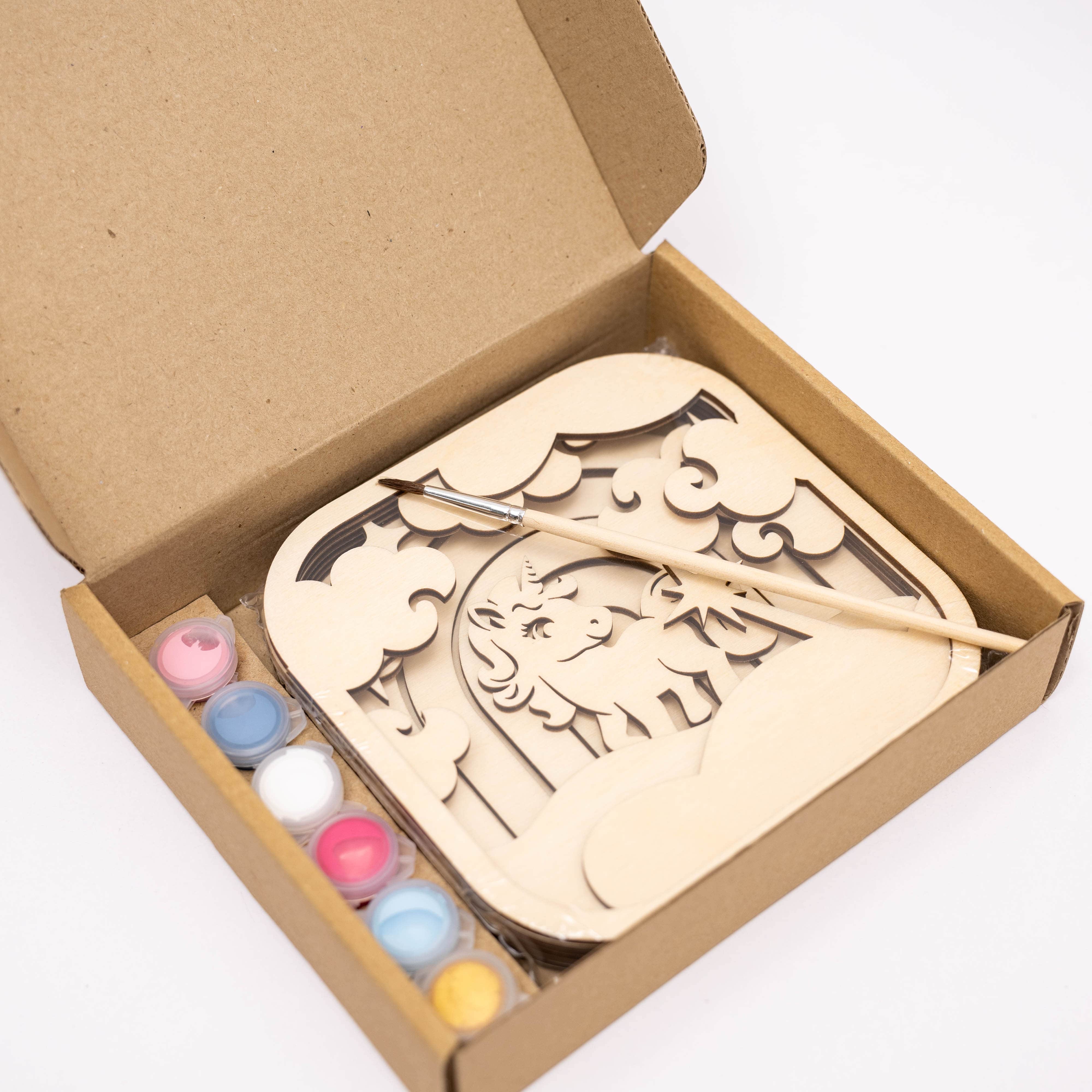 Wooden puzzle with colorful paint bottles in a cardboard box on a white background