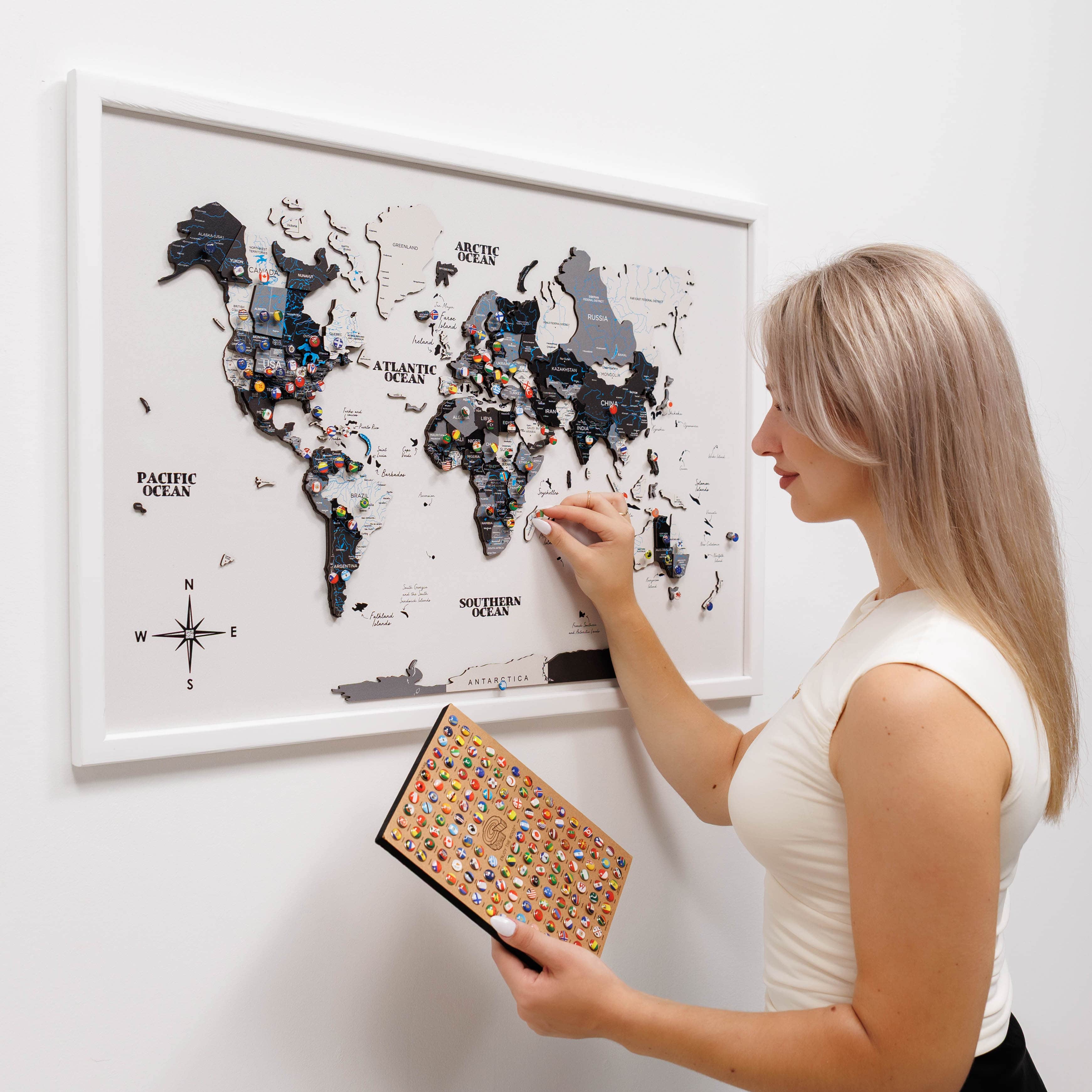Woman interacting with a world map poster on a wall