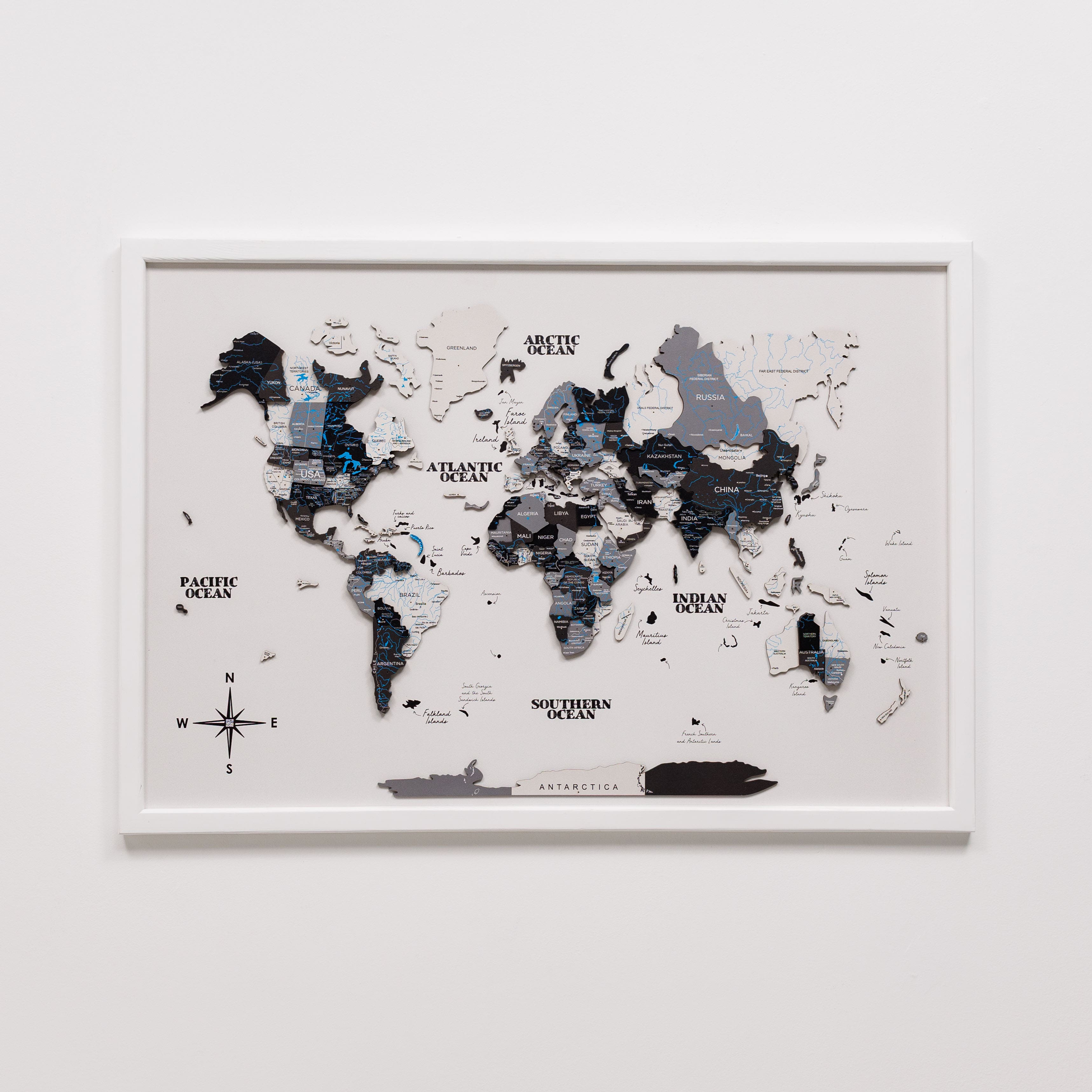 Framed world map with black and white design on a white wall