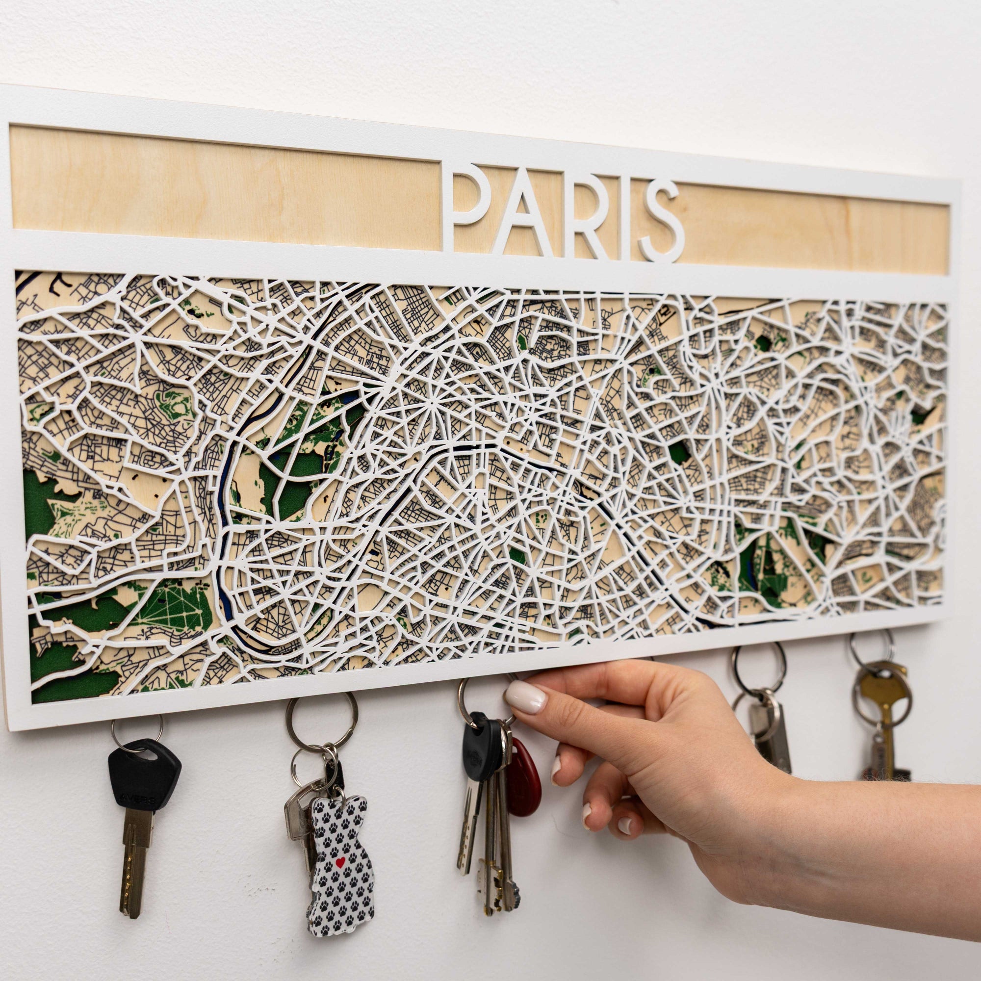 Key holder with a map of Paris and keys attached, on a white background