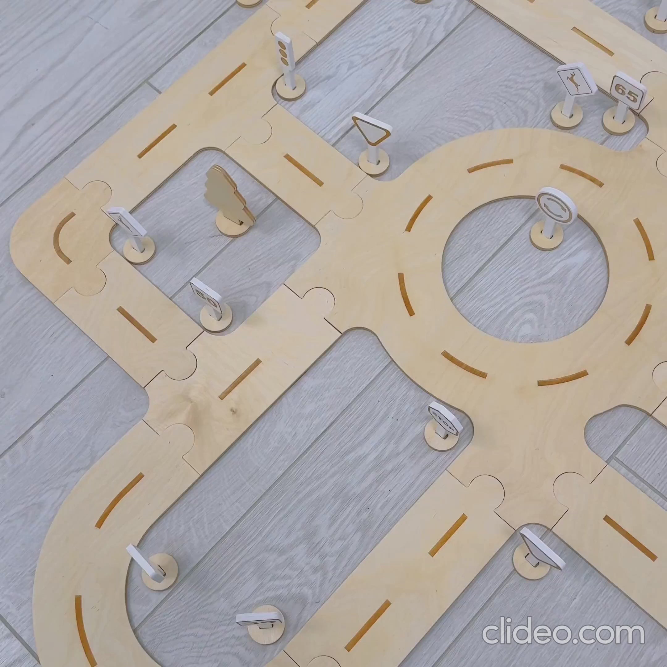 Wooden puzzle road track with roundabout and traffic signs for kids.