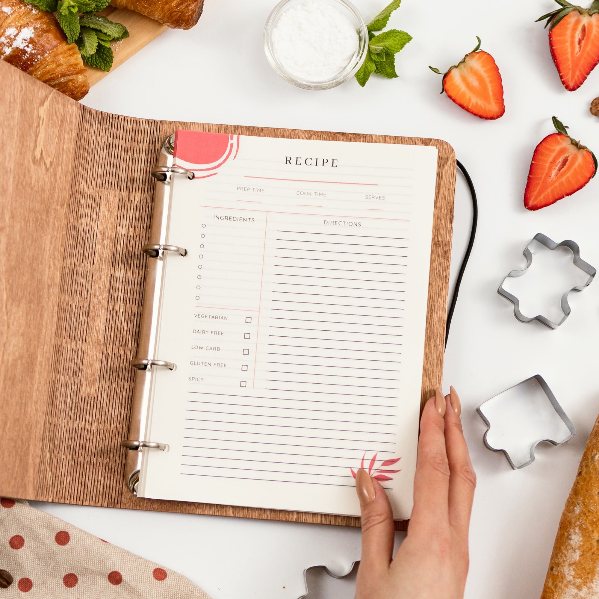 Open recipe book on a table with ingredients and tools