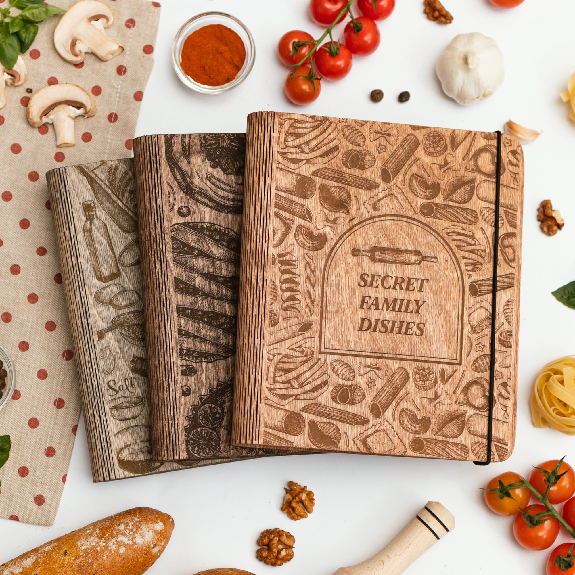Wooden recipe book titled 'Secret Family Dishes' surrounded by kitchen items on a white surface.