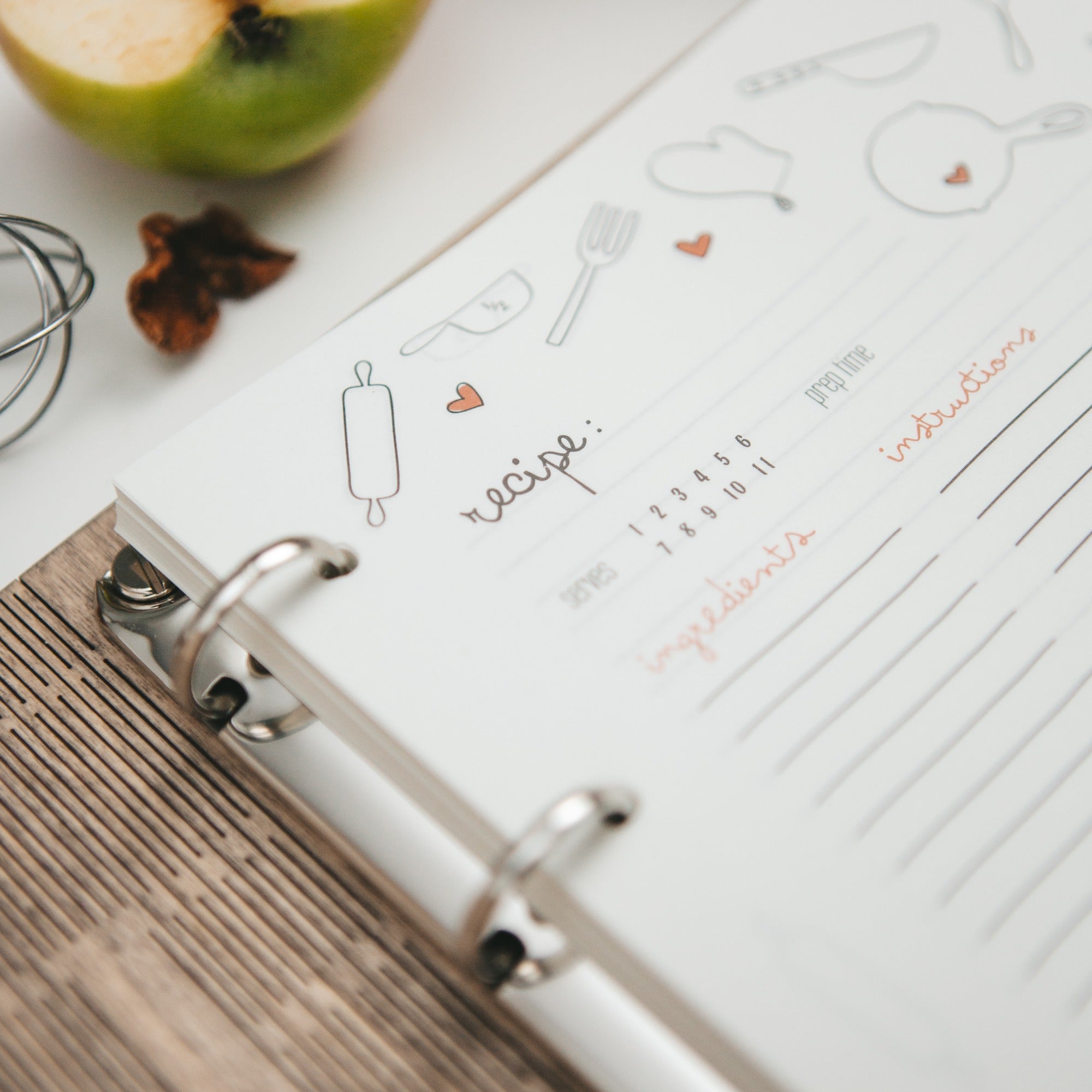 Open recipe book with ingredients on a wooden surface