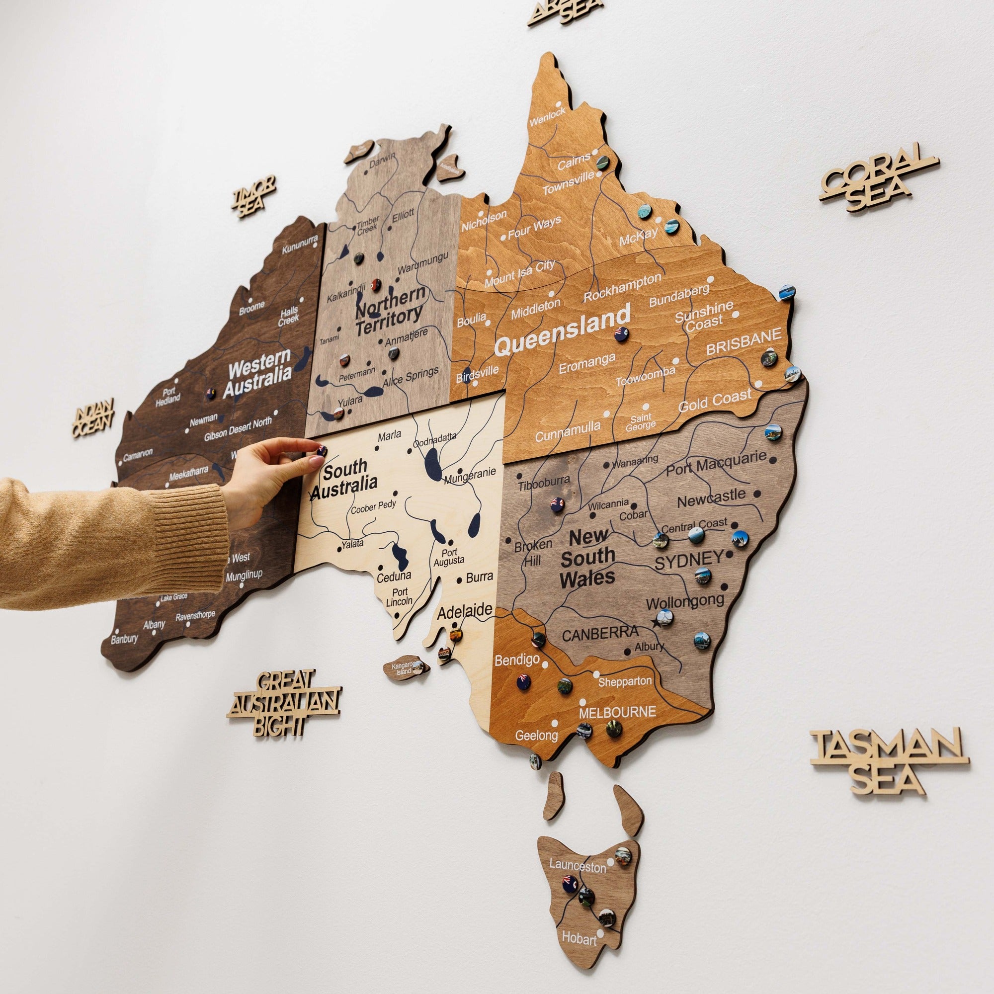 Wooden map of Australia with labeled states on a white background
