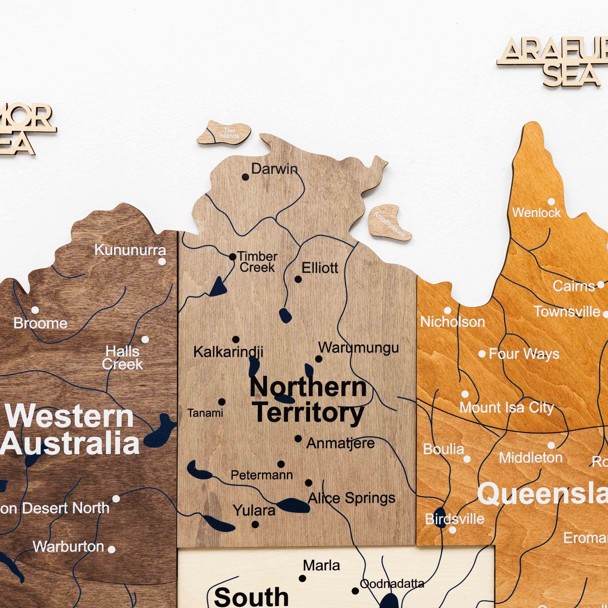 Wooden map of Australia with different regions highlighted in various colors.