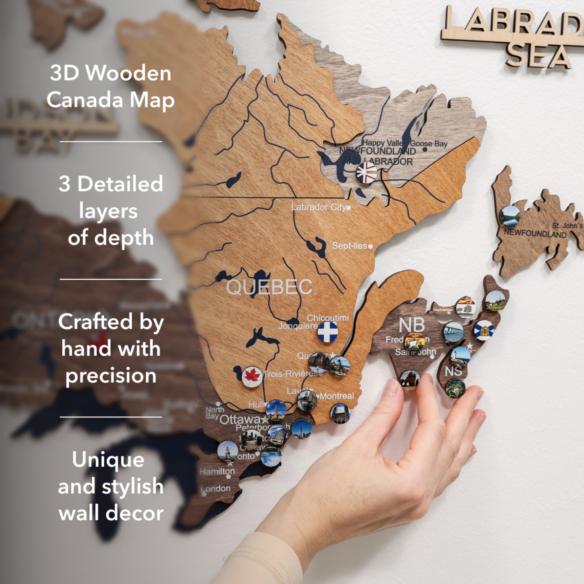 3D wooden Canada map with hand holding it, labeled 'Labrad Sea'.