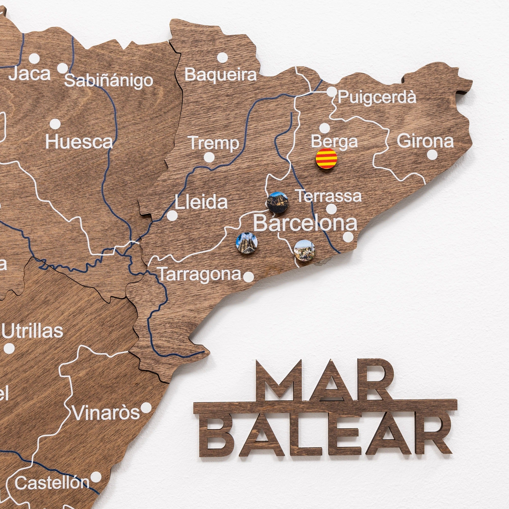 Wooden map of Catalonia with pins marking locations, featuring 'Mar Balear' at the bottom.