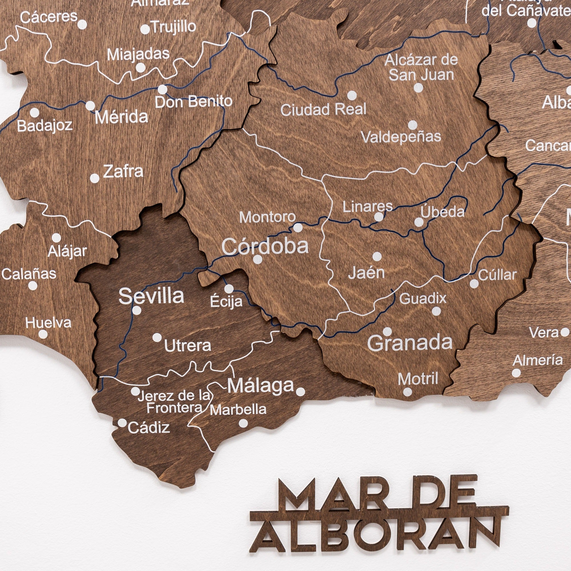 Wooden map of Andalusia with cities labeled on a white background
