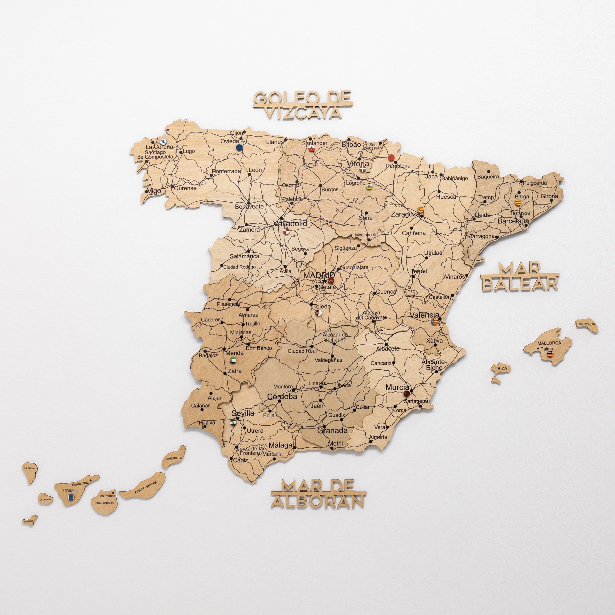 Wooden map of Spain with regions labeled on a white background