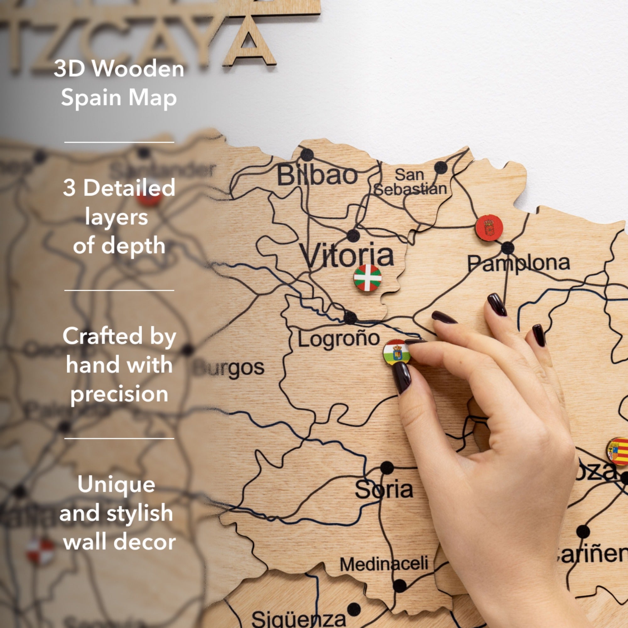 Wooden map of Spain with a hand pointing to Vitoria, featuring text about its features.