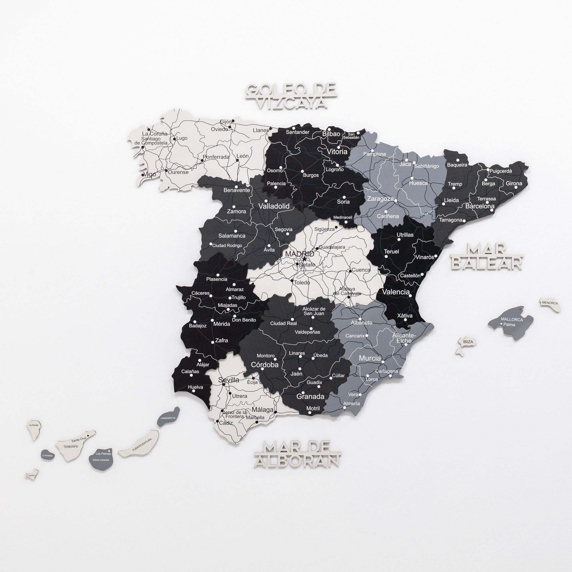 Wooden map of Spain with regions labeled on a white background