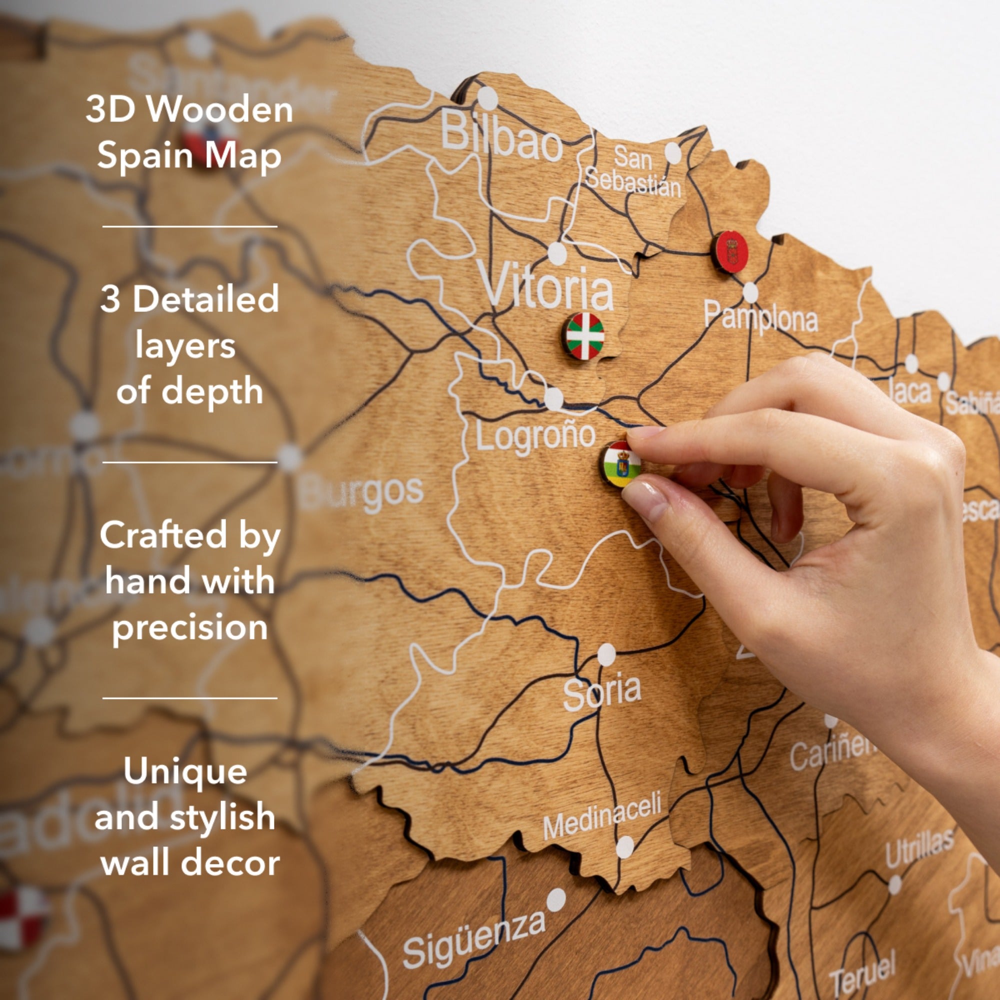 3D wooden Spain map with hand placing a pin, highlighting features like detailed layers and handcrafting.