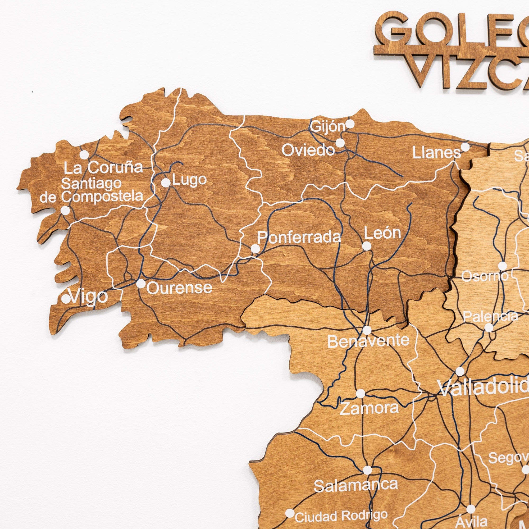 Wooden map of Galicia with cities labeled on a white background