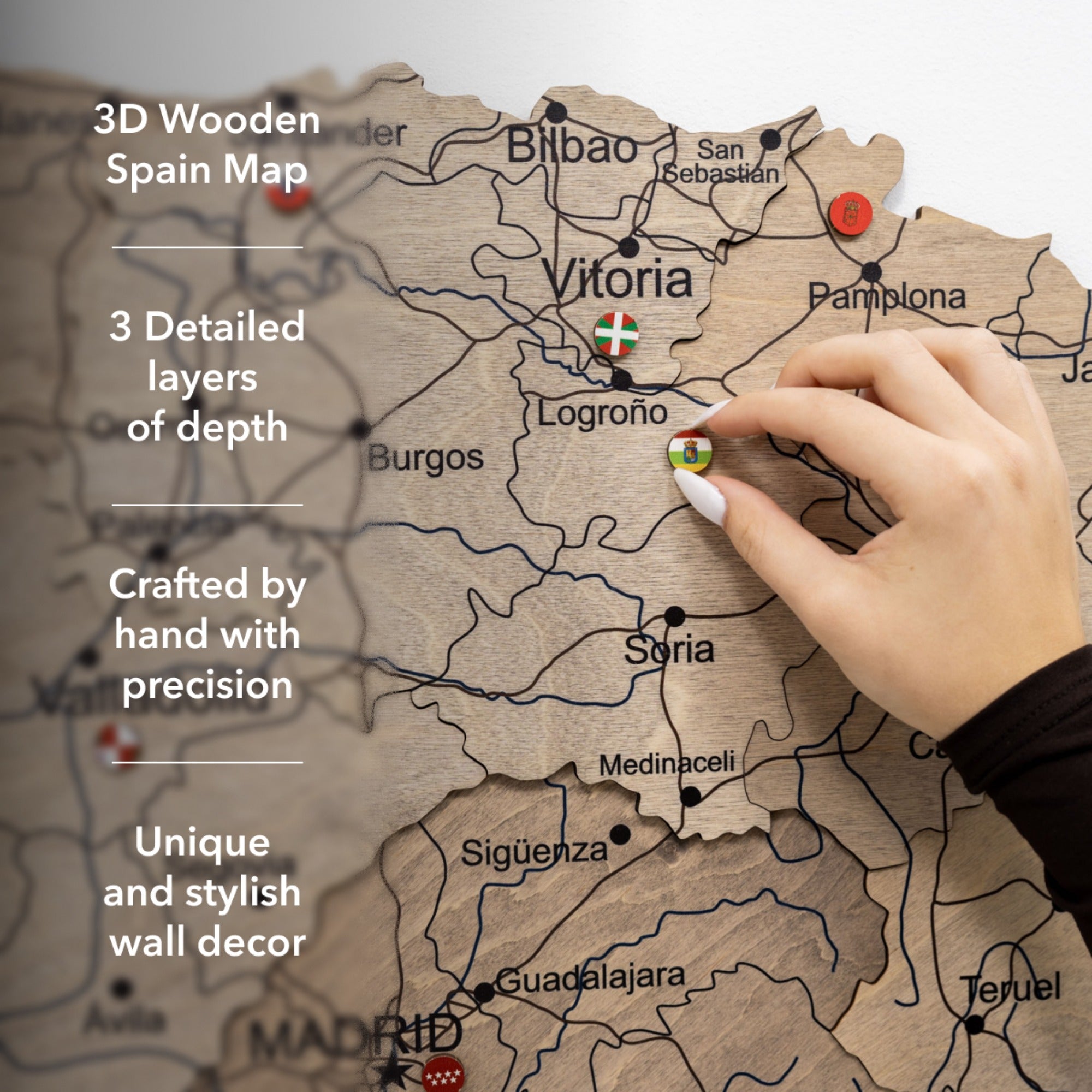 Wooden map of Spain with a hand interacting with it, highlighting features like detailed layers and hand-crafted quality.