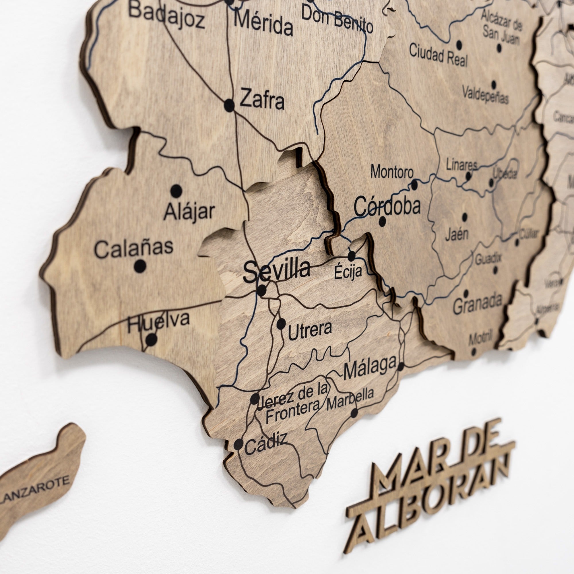 Wooden map of Andalusia with cities labeled on a white background