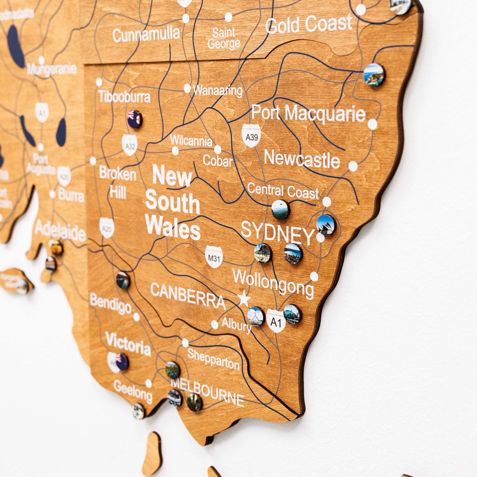 Wooden map of New South Wales with cities labeled on a white background