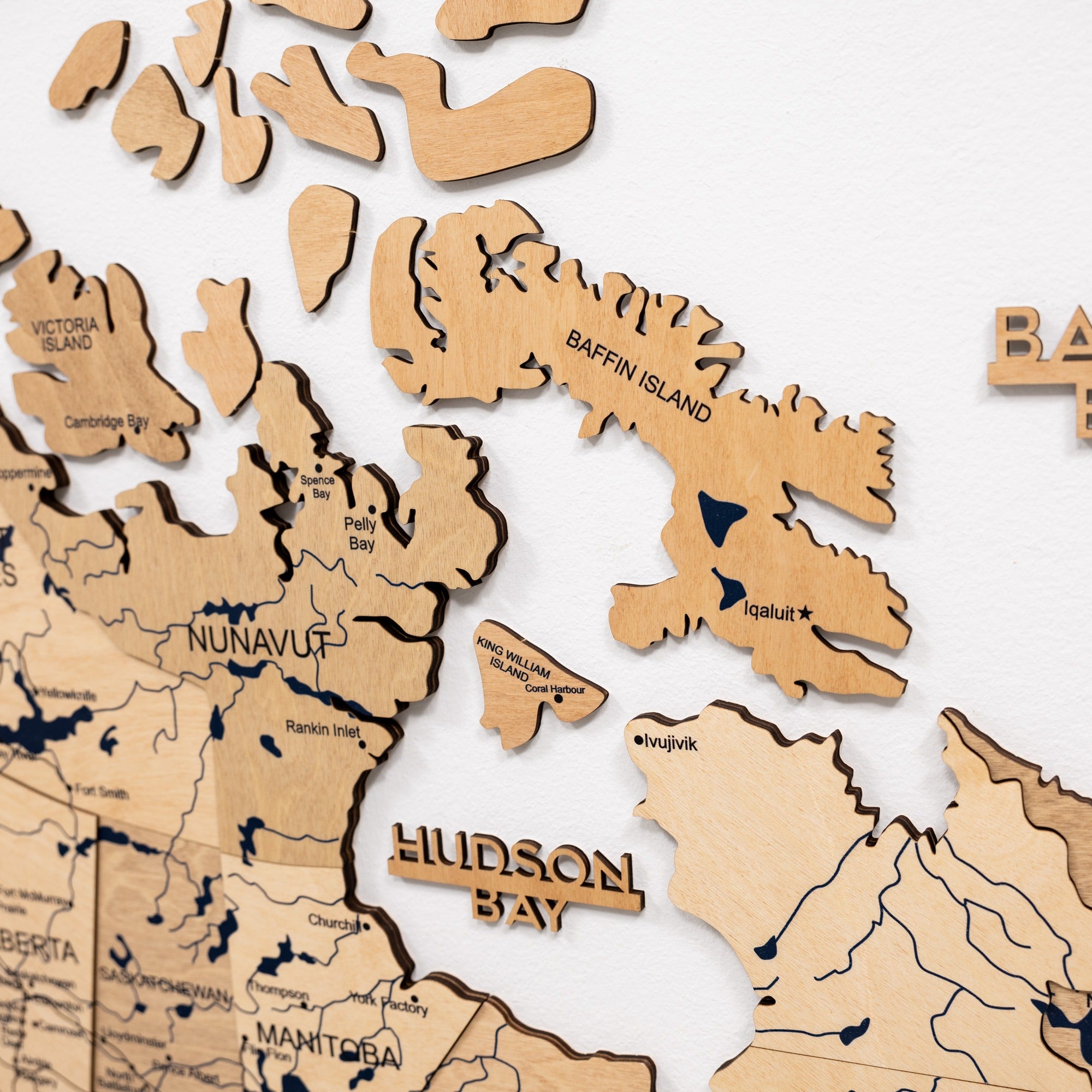 Wooden map puzzle of Canada with various pieces on a white background