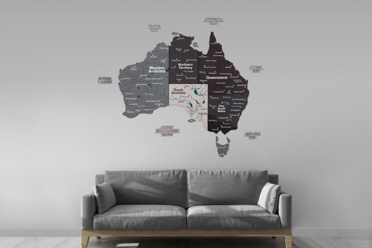 Wall decal of Australia with state names on a gray wall above a gray sofa.