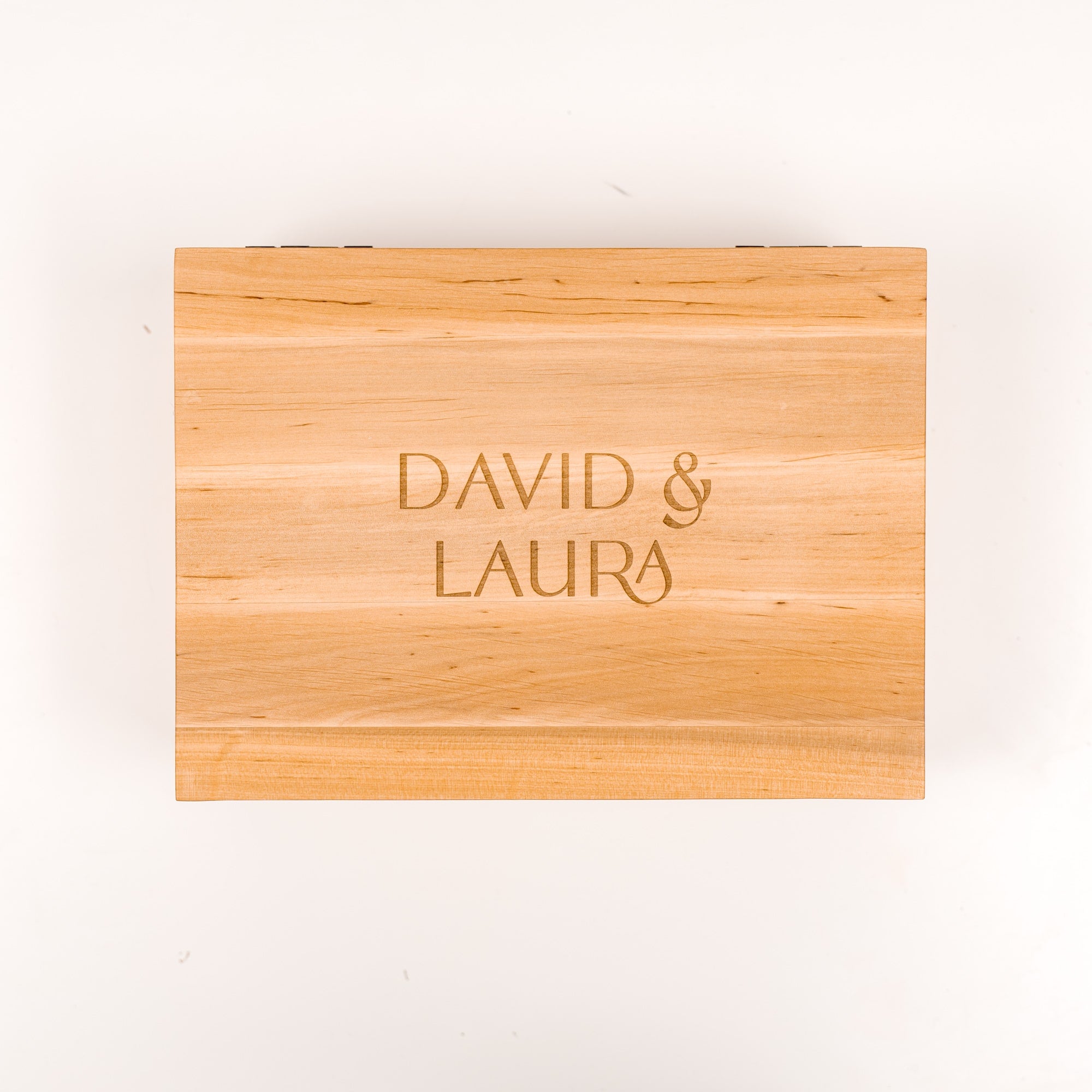 Wooden cutting board with 'DAVID & LAURA' engraving on a white background