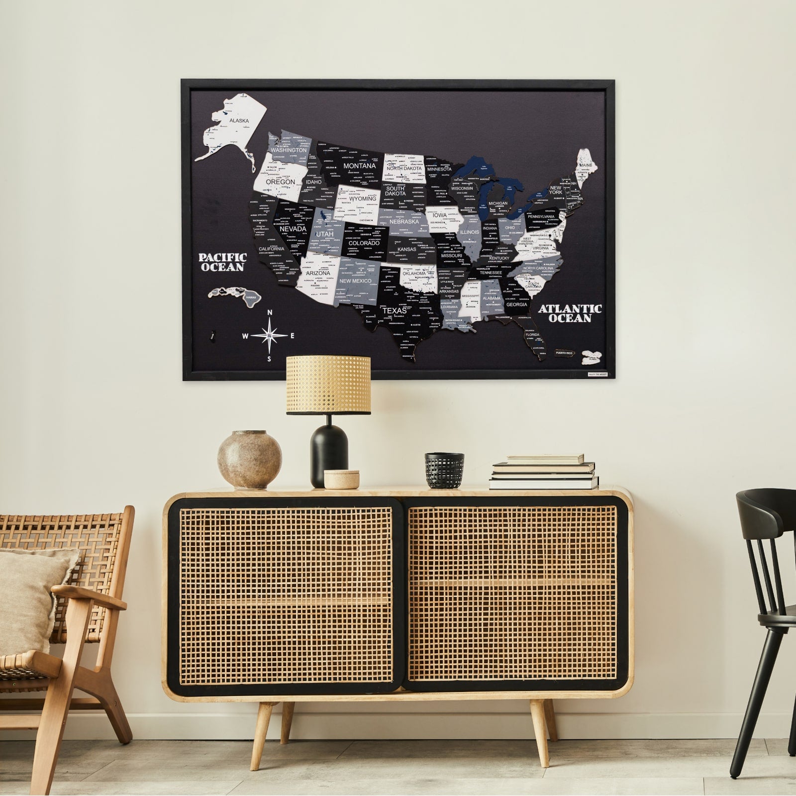 Framed map of the United States on a wall above a wooden cabinet in a room.