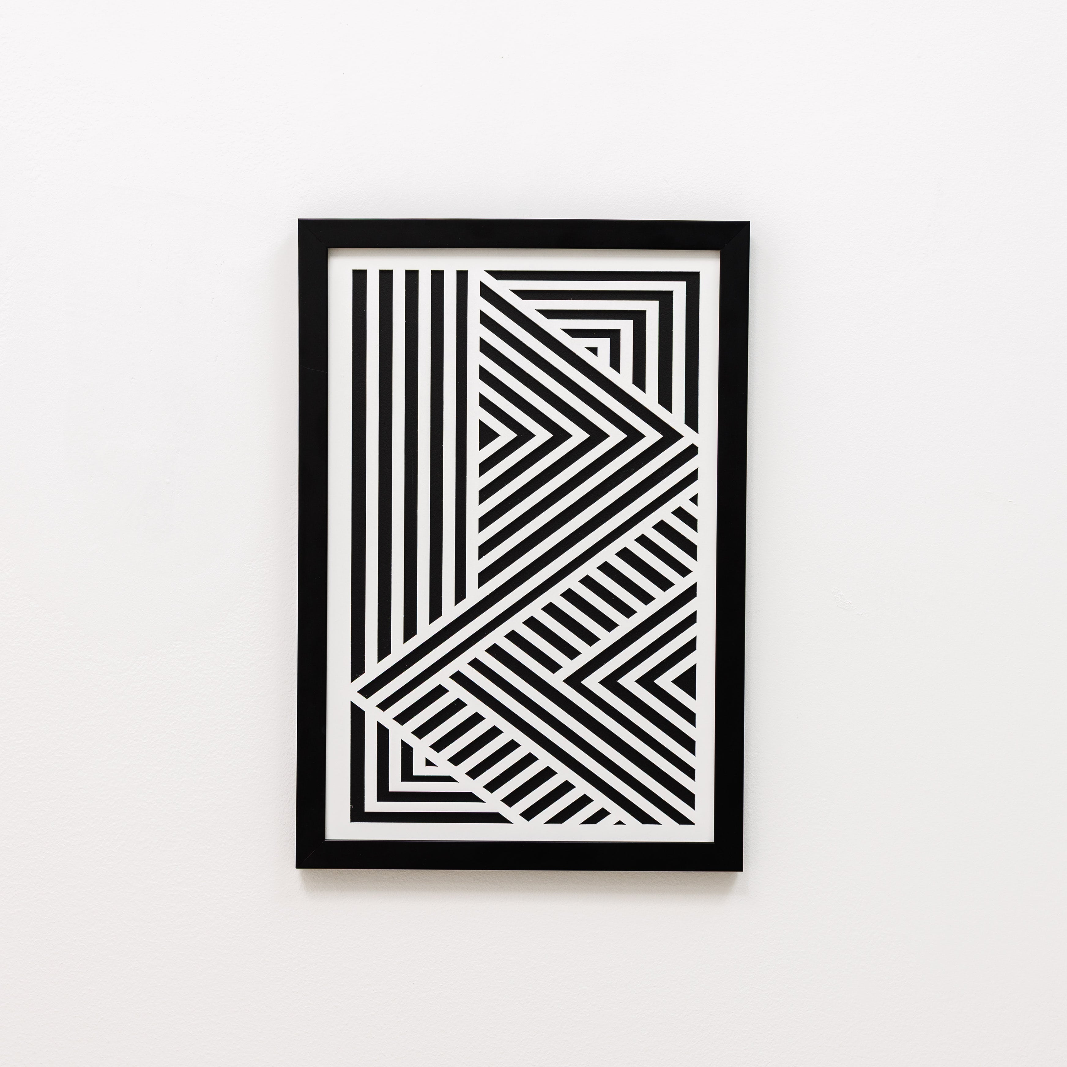 Framed black and white geometric art print on a white wall