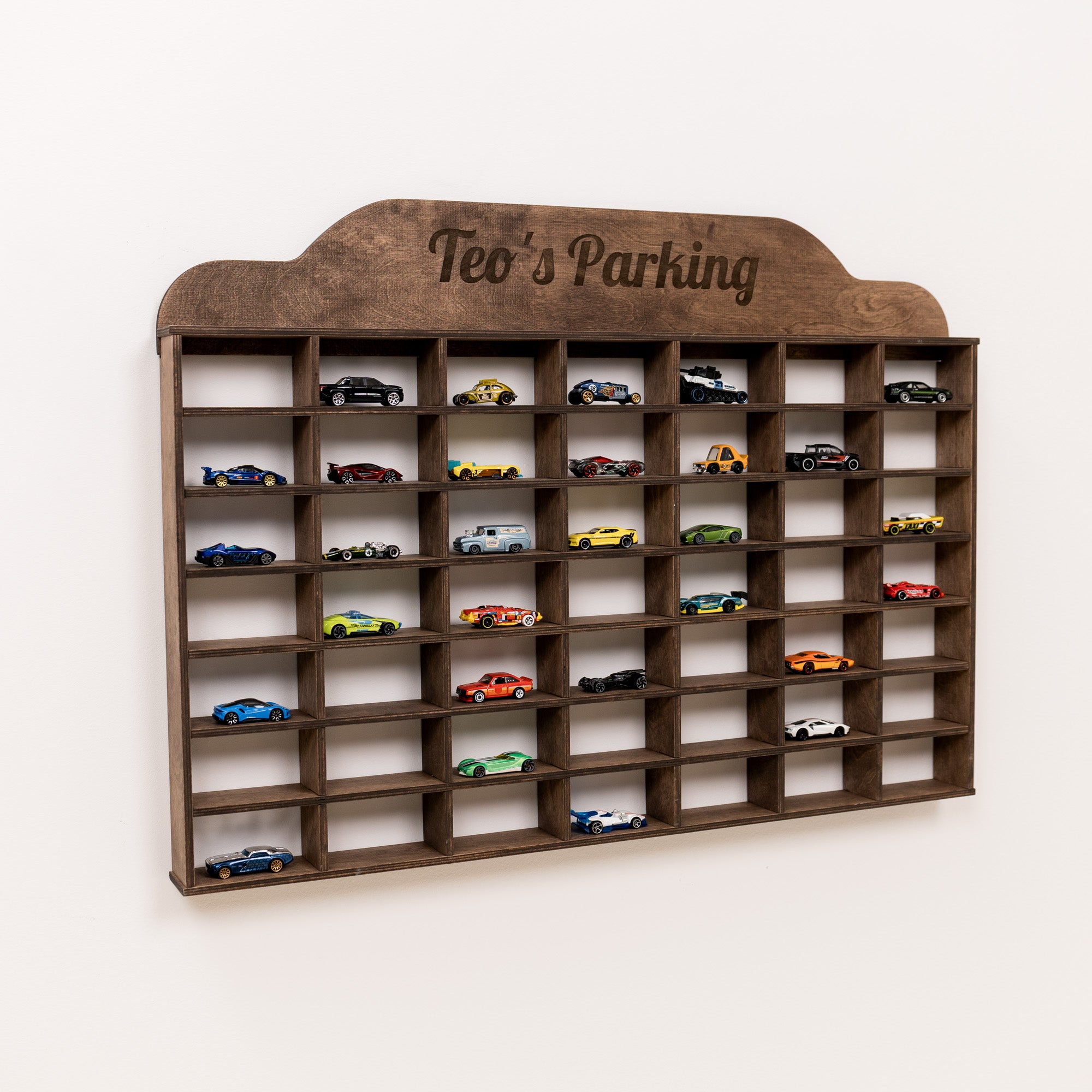 Wooden toy car parking garage with multiple toy cars on a white background