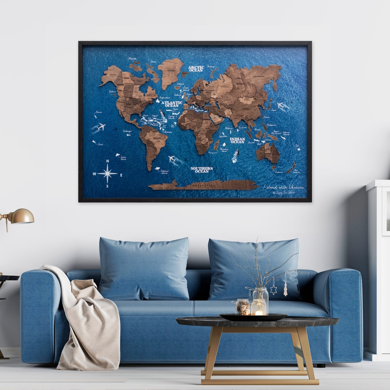World map on the wall above a blue sofa in a living room.