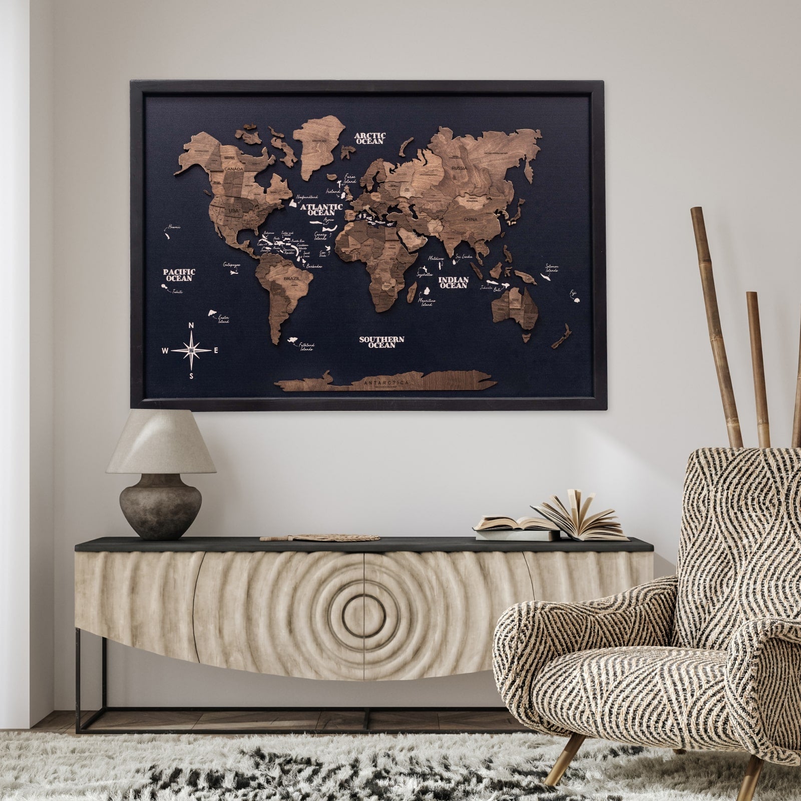 World map on the wall above a console table with a chair and lamp in a room.