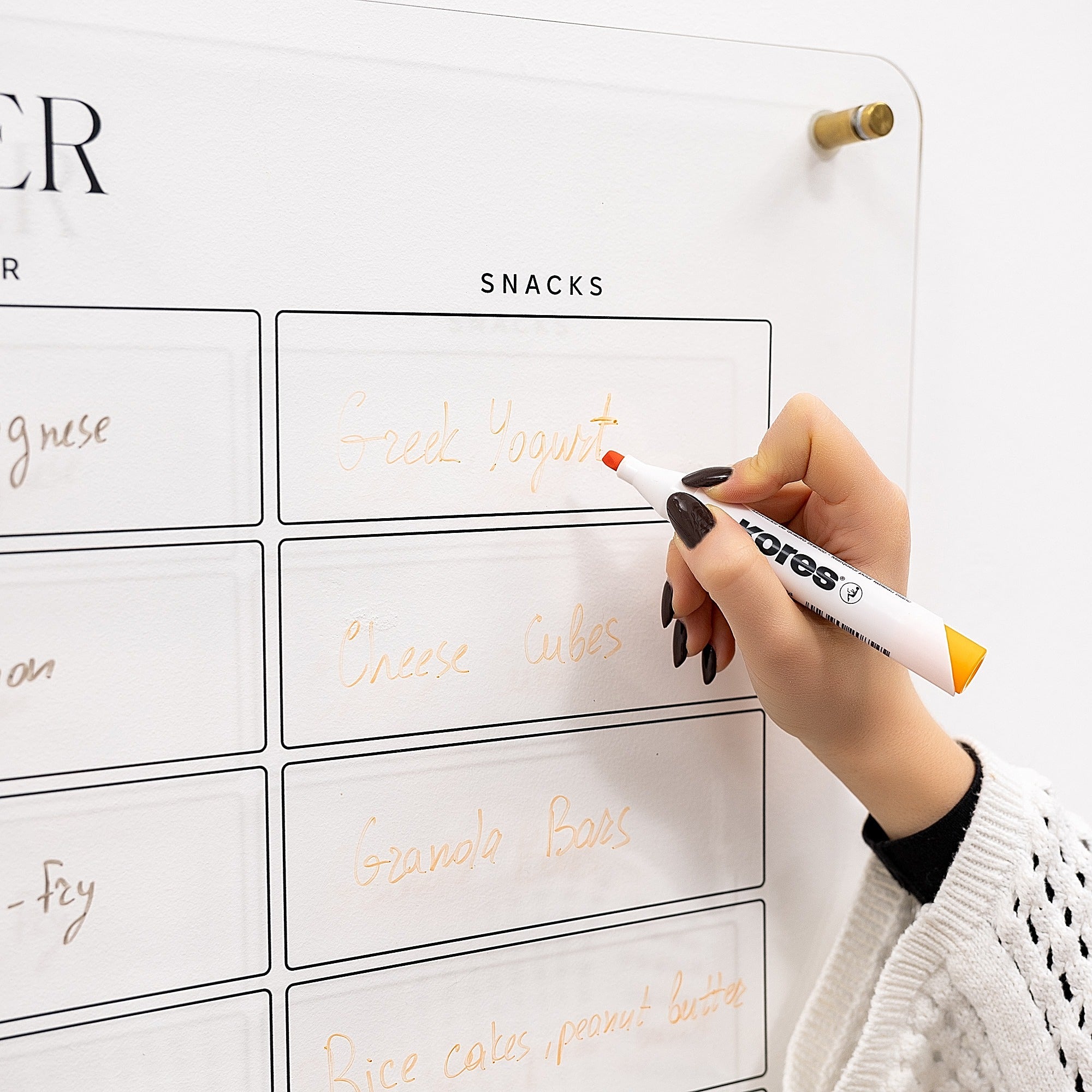 Person writing on a whiteboard with a marker, labeled 'SNACKS' at the top.