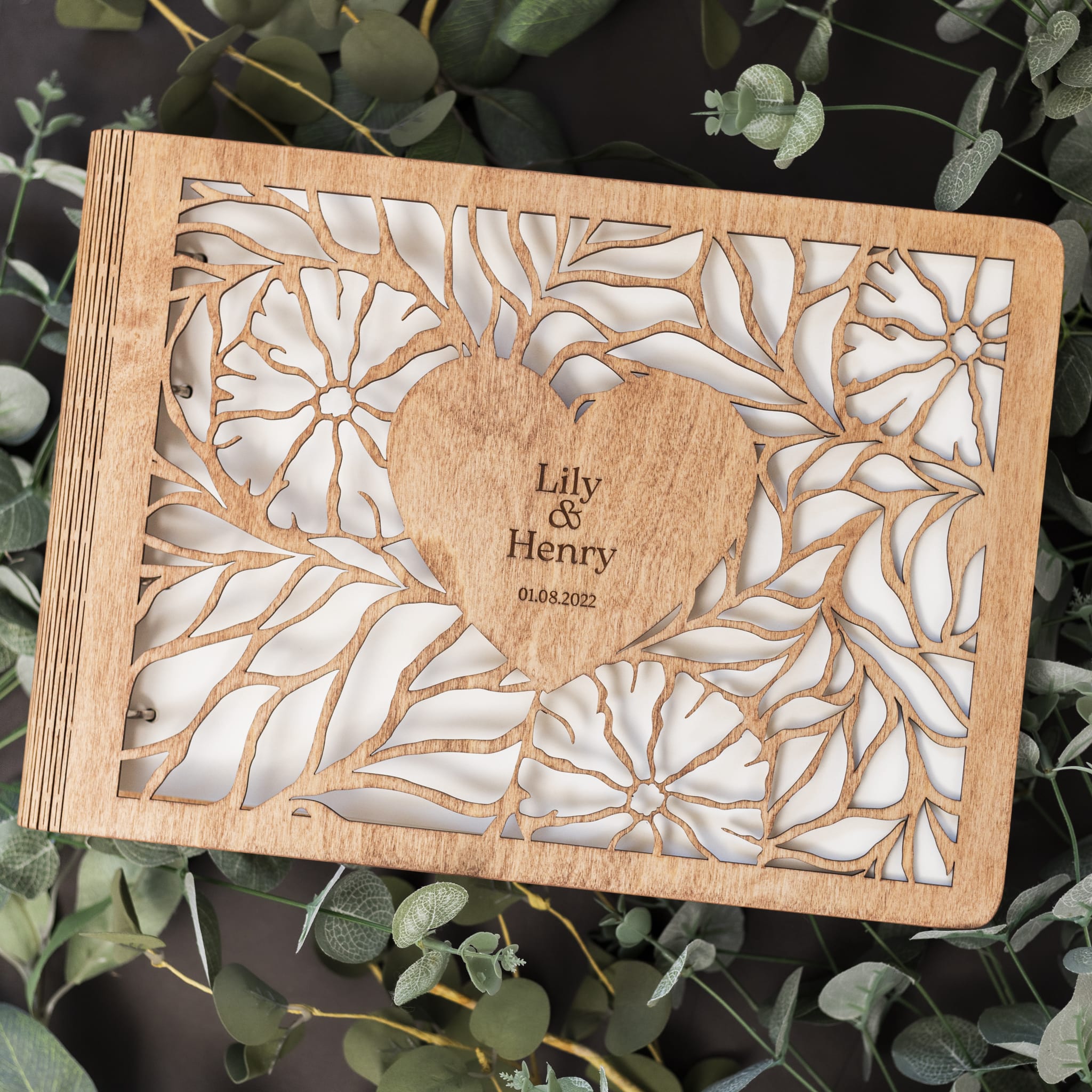 Wooden card with laser-cut design and engraved text on a green leaf background