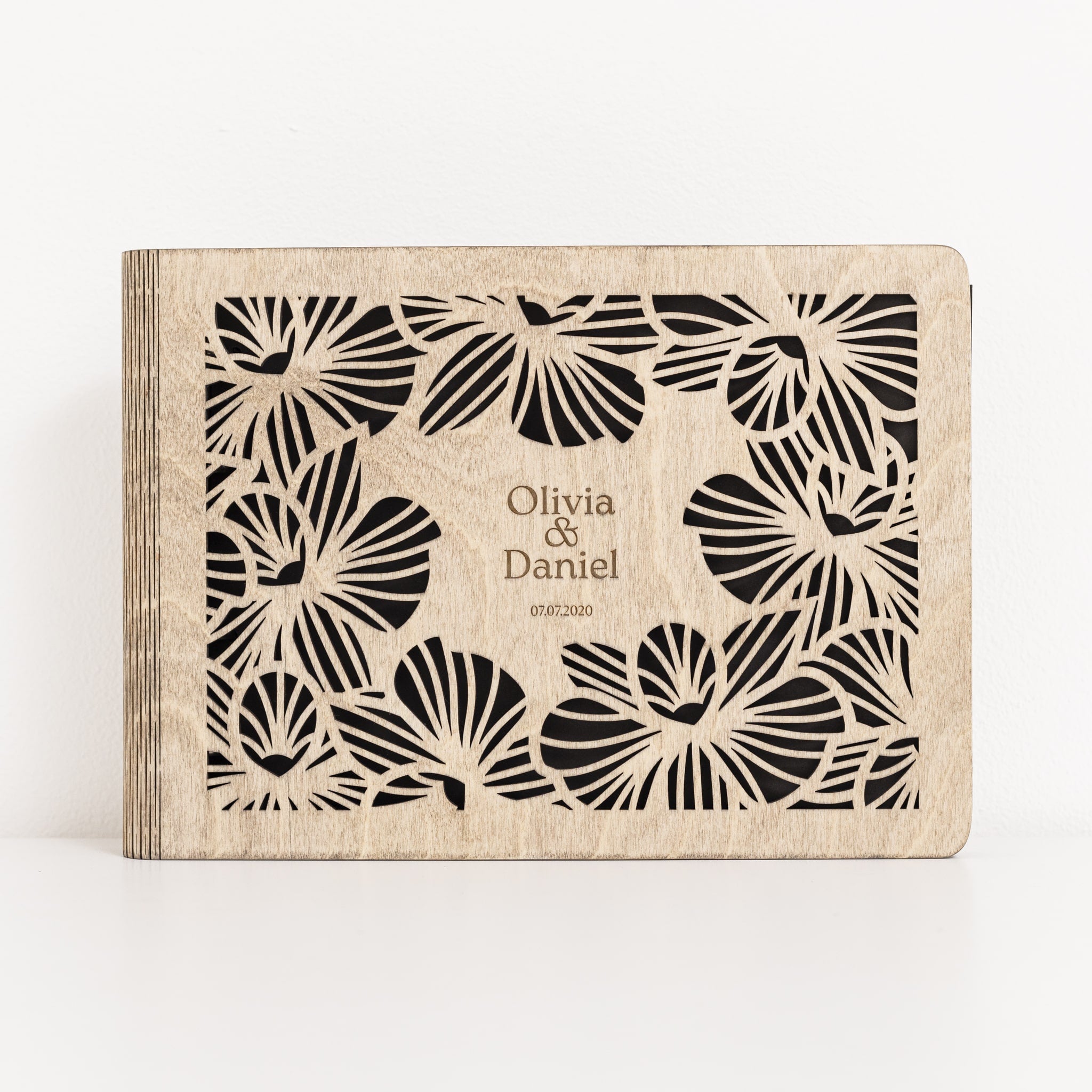 Personalized photo album with floral design and 'Olivia & Daniel' text on a white background