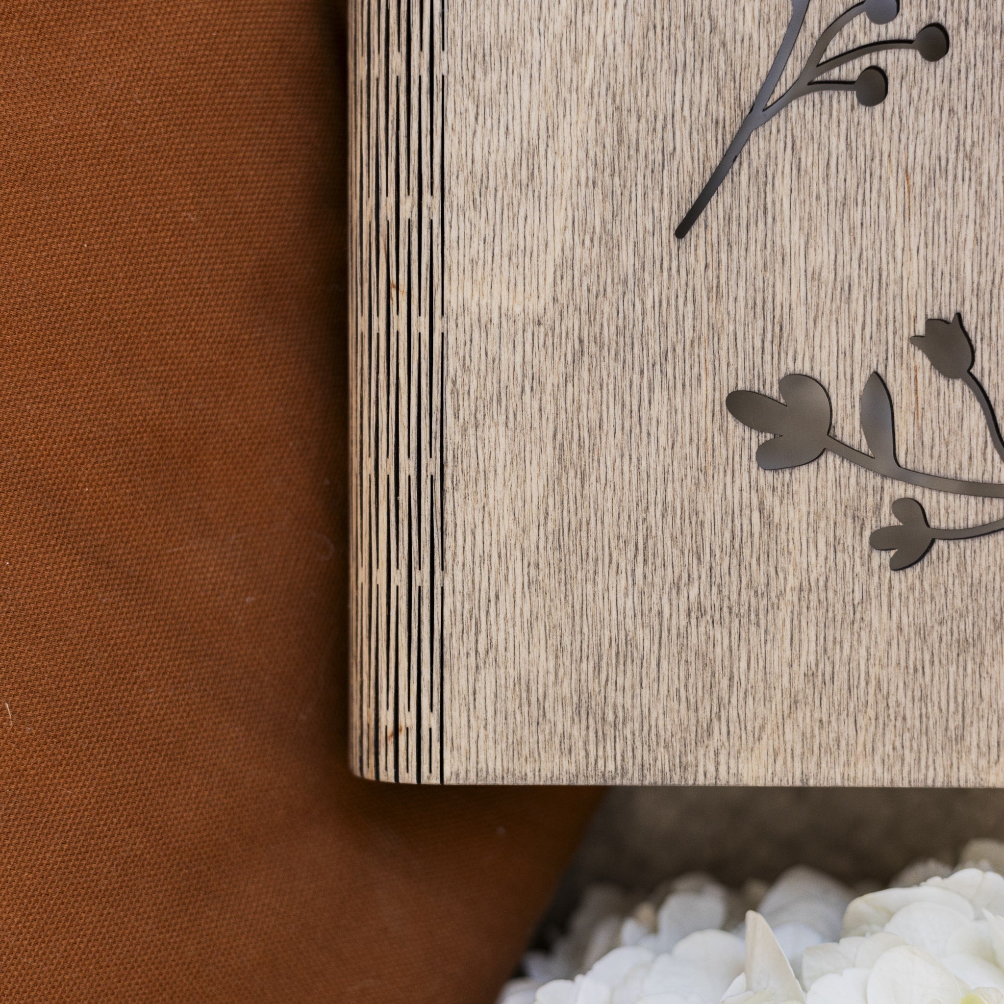 Wooden box with floral cutout on a textured surface