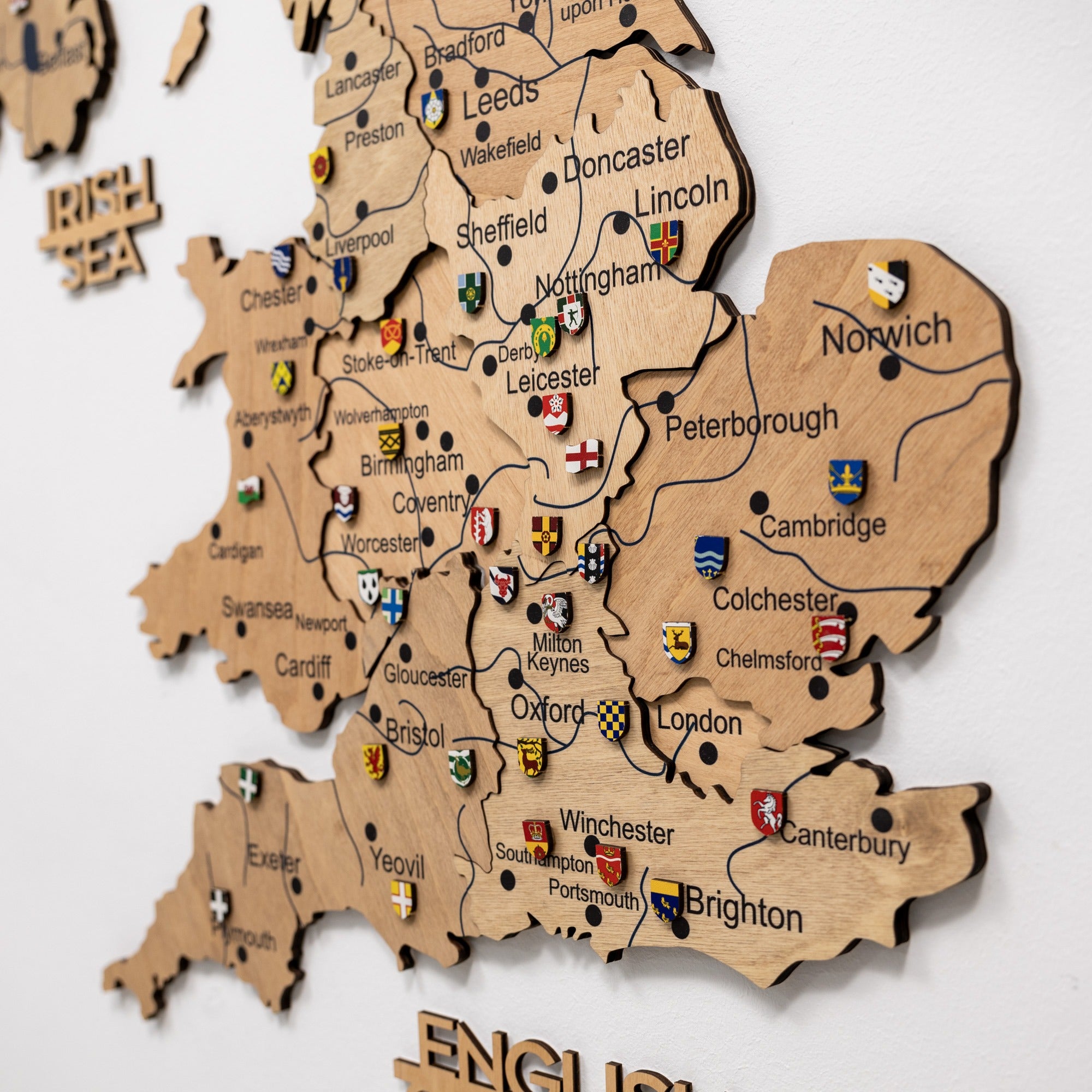 Wooden map of England with city names and flags on a white background