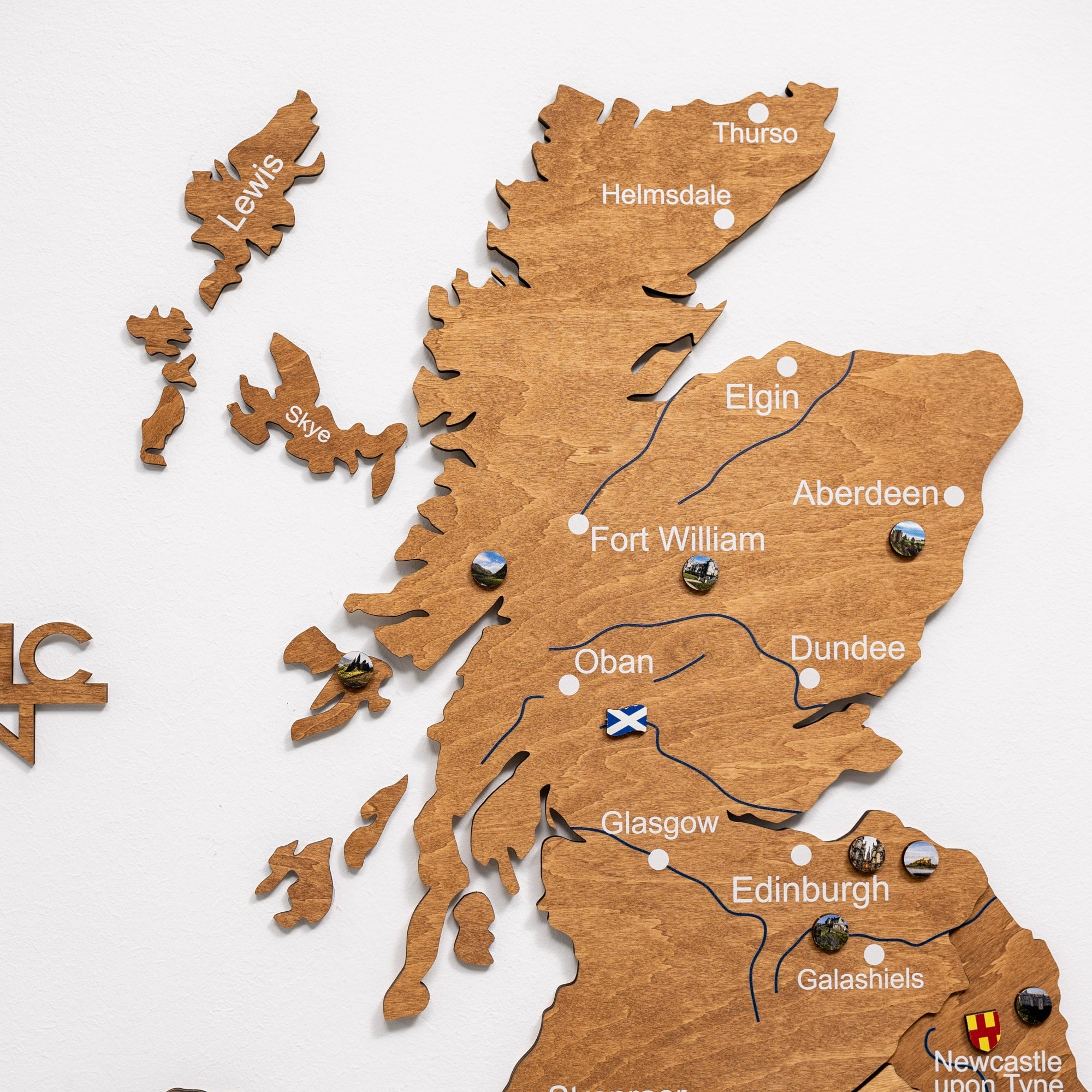 Wooden map of Scotland with cities labeled on a white background