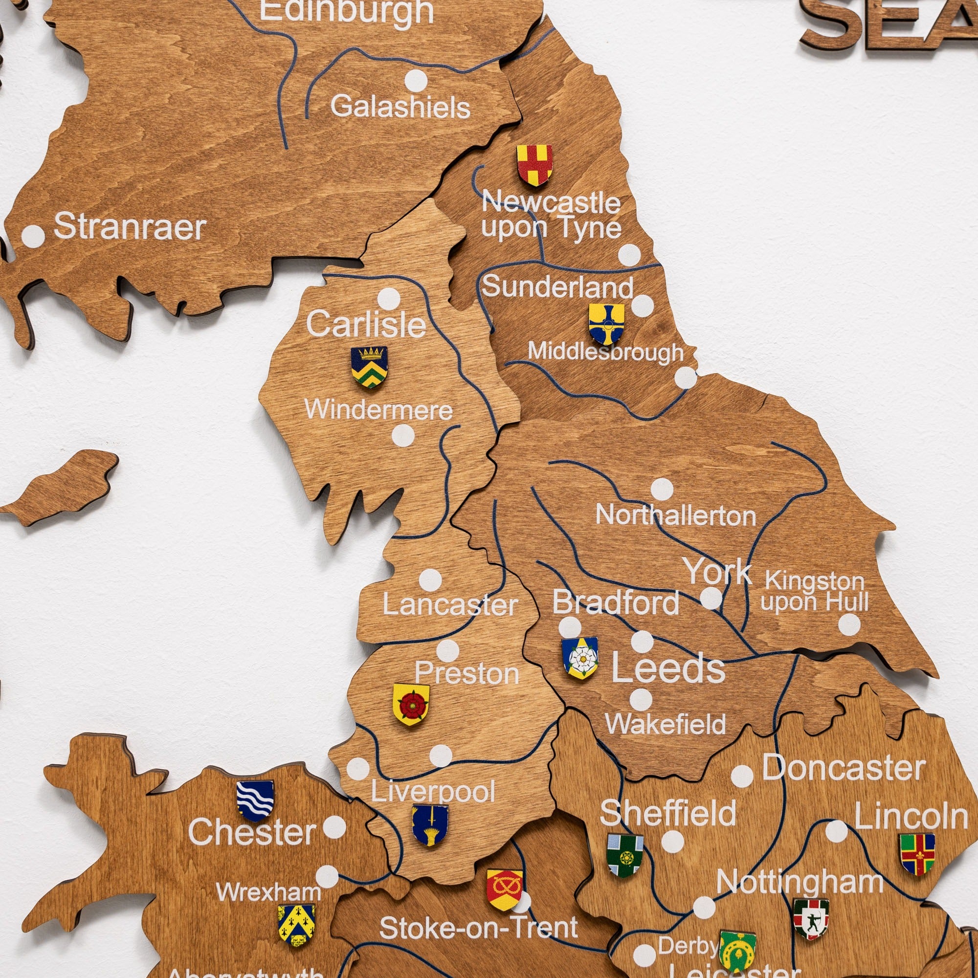 Wooden map of the United Kingdom with cities labeled and flags.