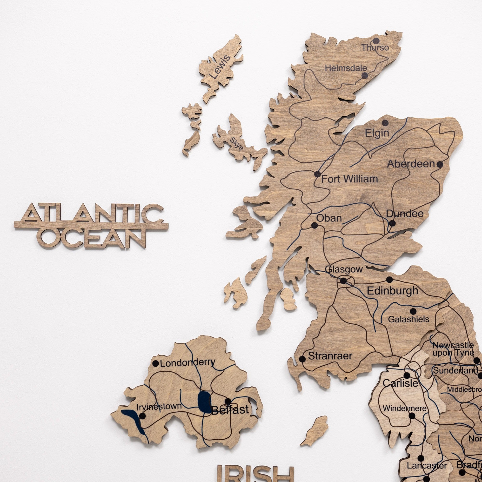 Wooden puzzle map of Scotland with cities labeled on a white background