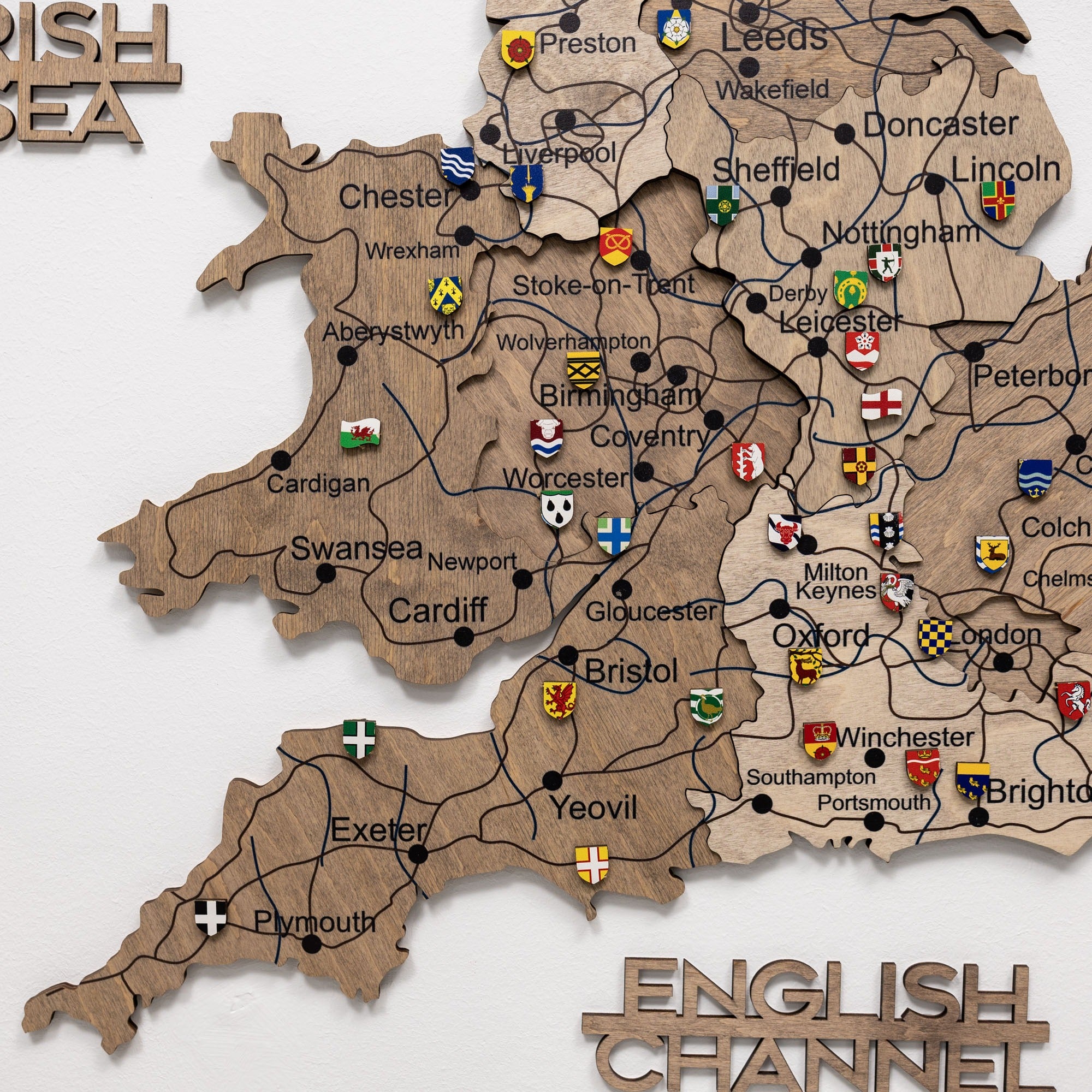 Wooden map of England with city names and flags on a white background