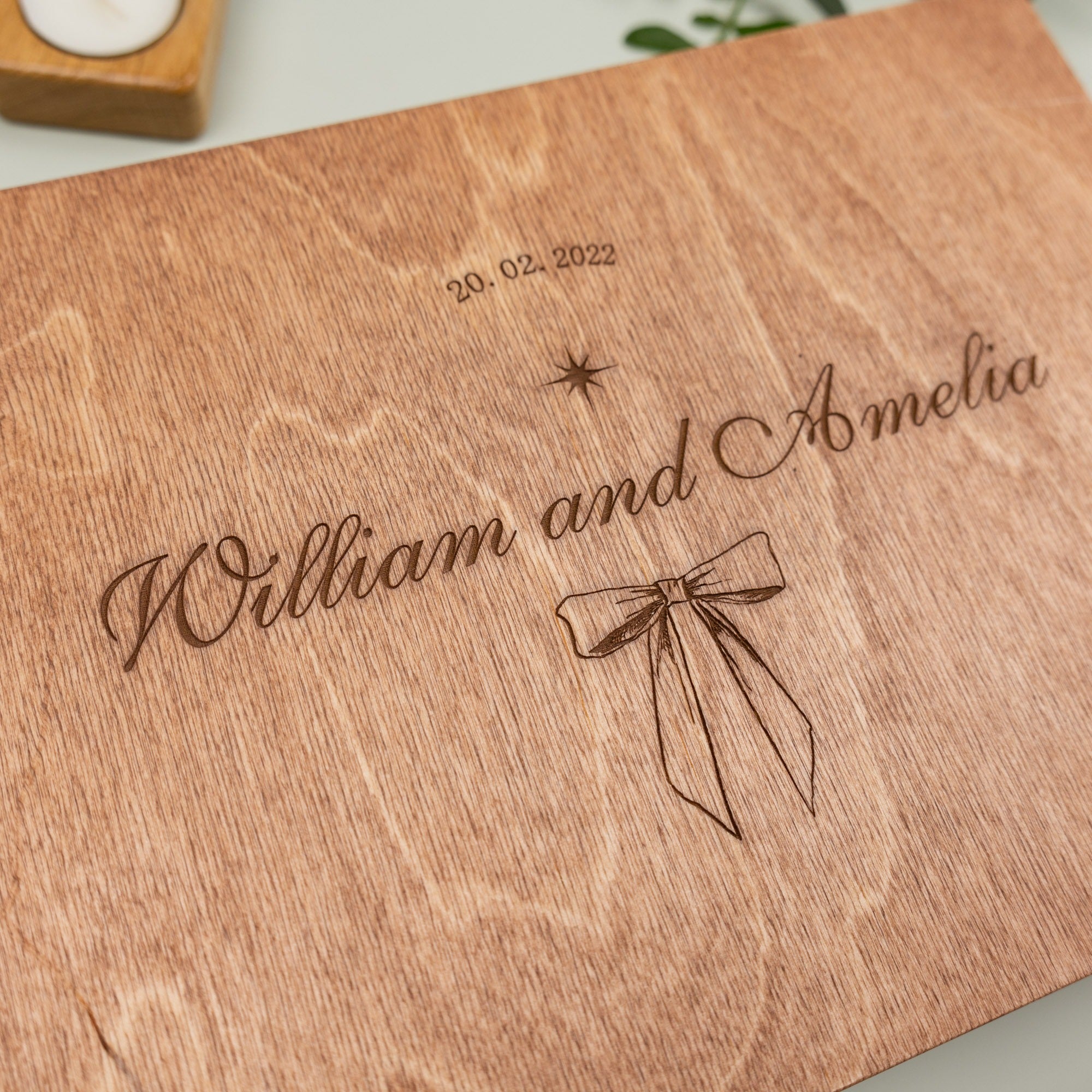Wooden board with engraved names 'William and Amelia' and date '20.02.2022'.