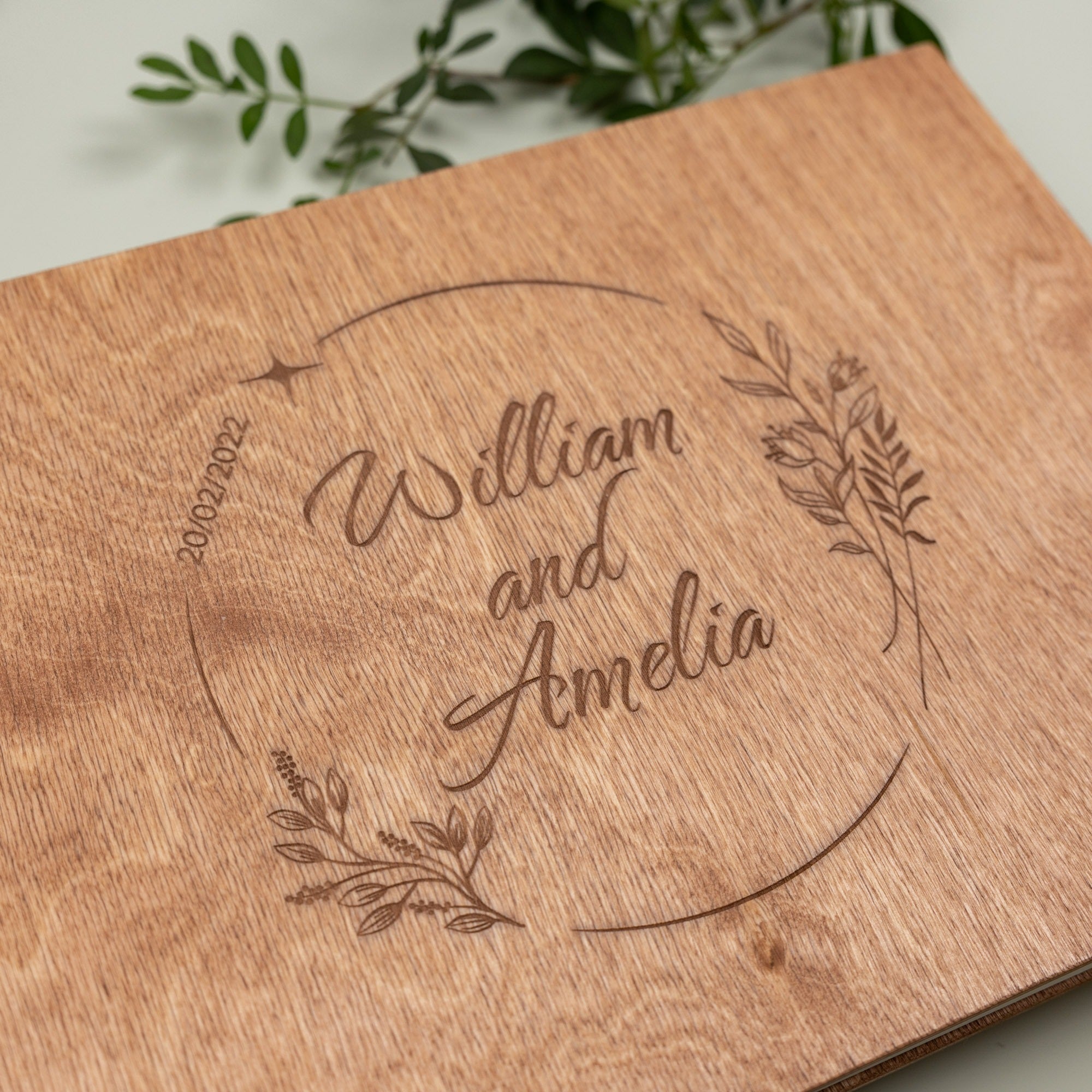 Wooden plaque with engraved names 'William and Amelia' and decorative elements.