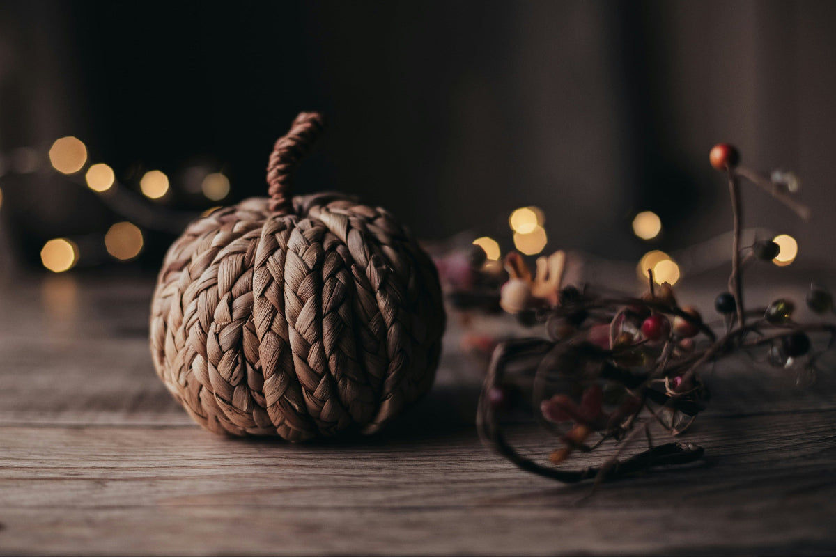 A knotted beige pumpkin toy placed on a rustic wooden table