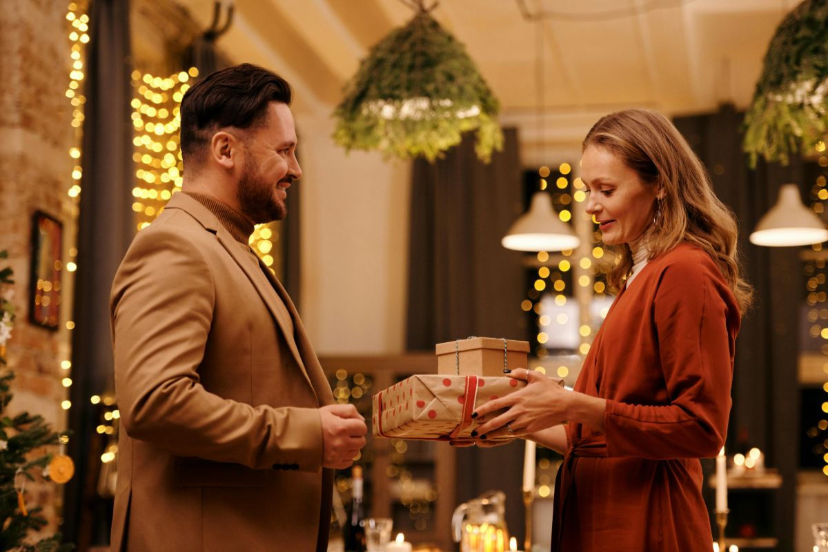 Woman giving Christmas presents to a man