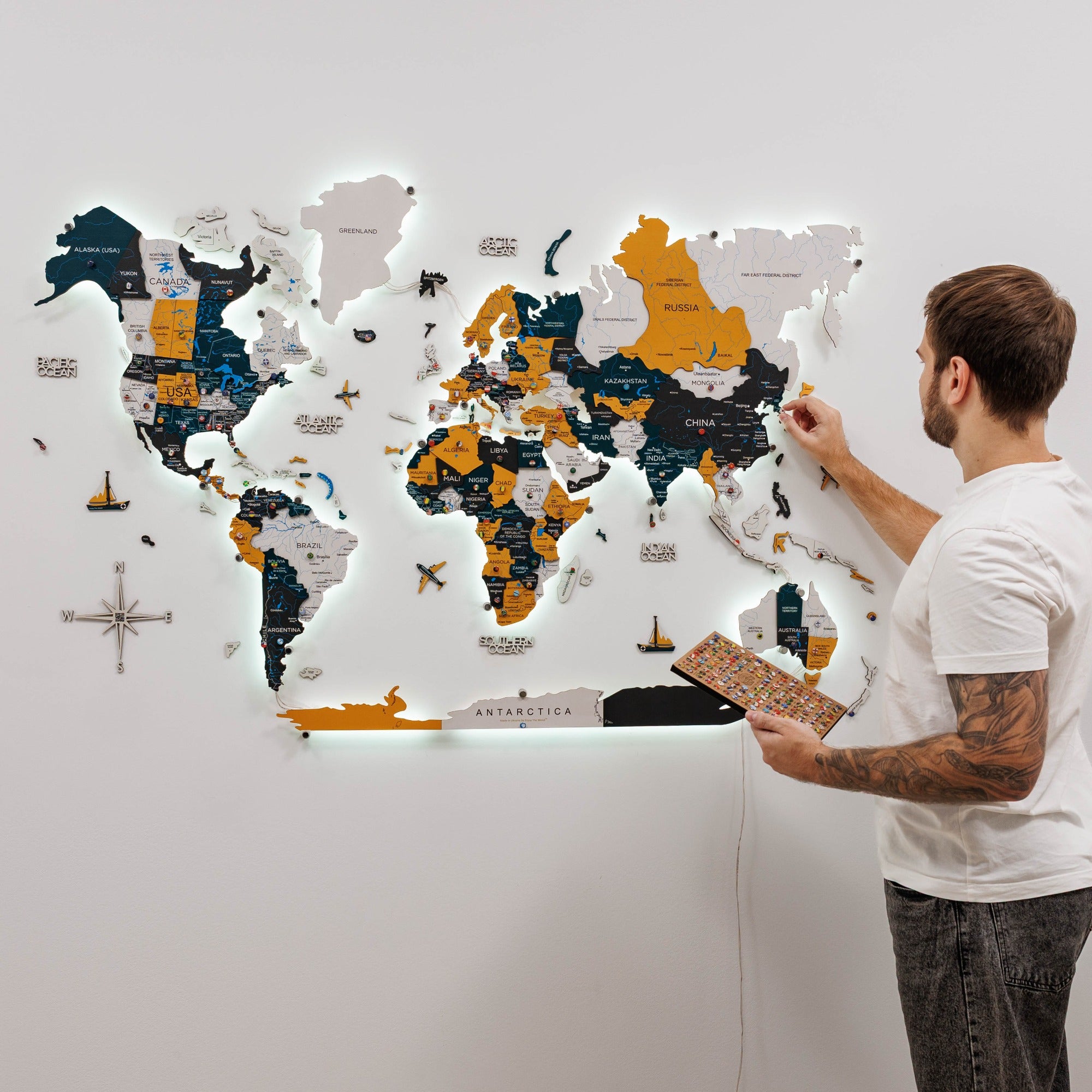 Man interacting with a world map puzzle on a wall