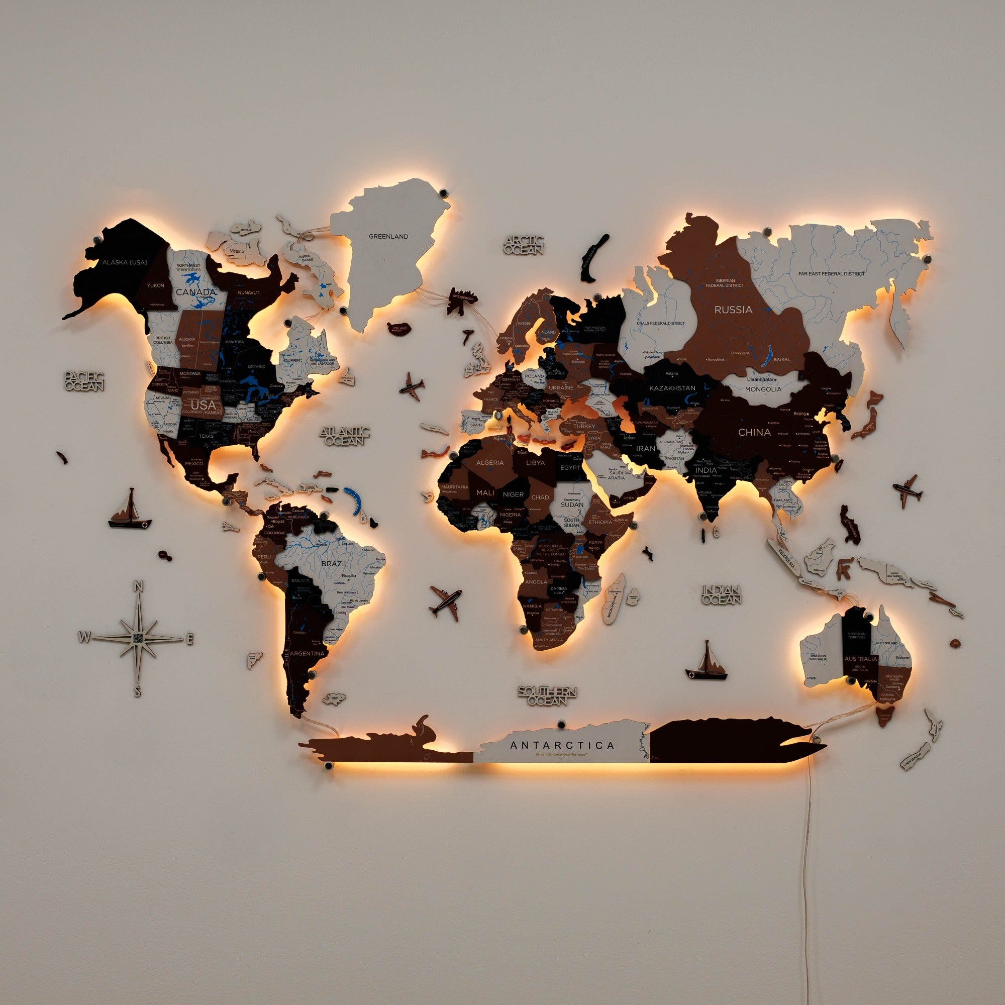 World map with illuminated edges on a plain wall