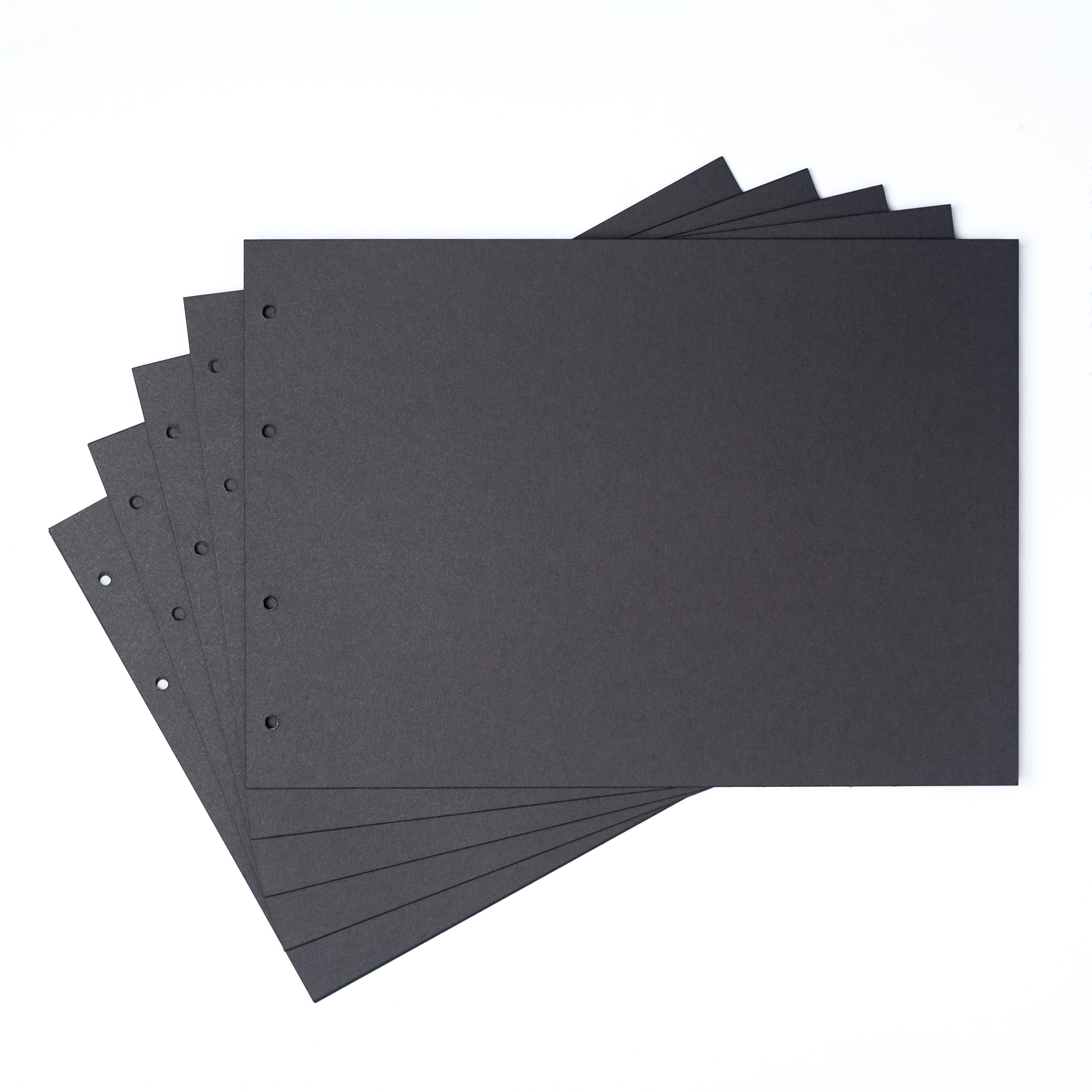 Stack of black sheets with holes on a white background