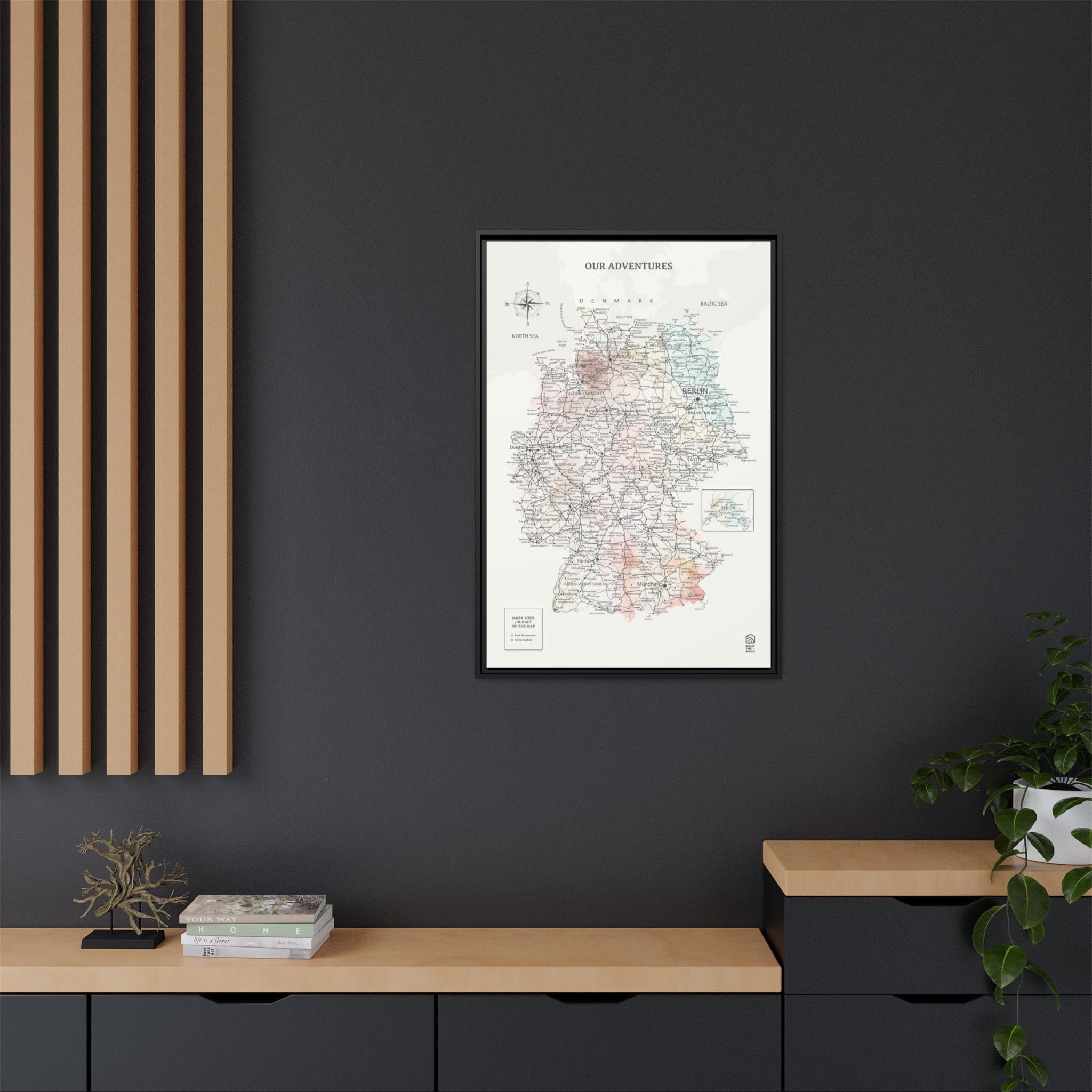 Framed map print on a dark wall with wooden shelves below