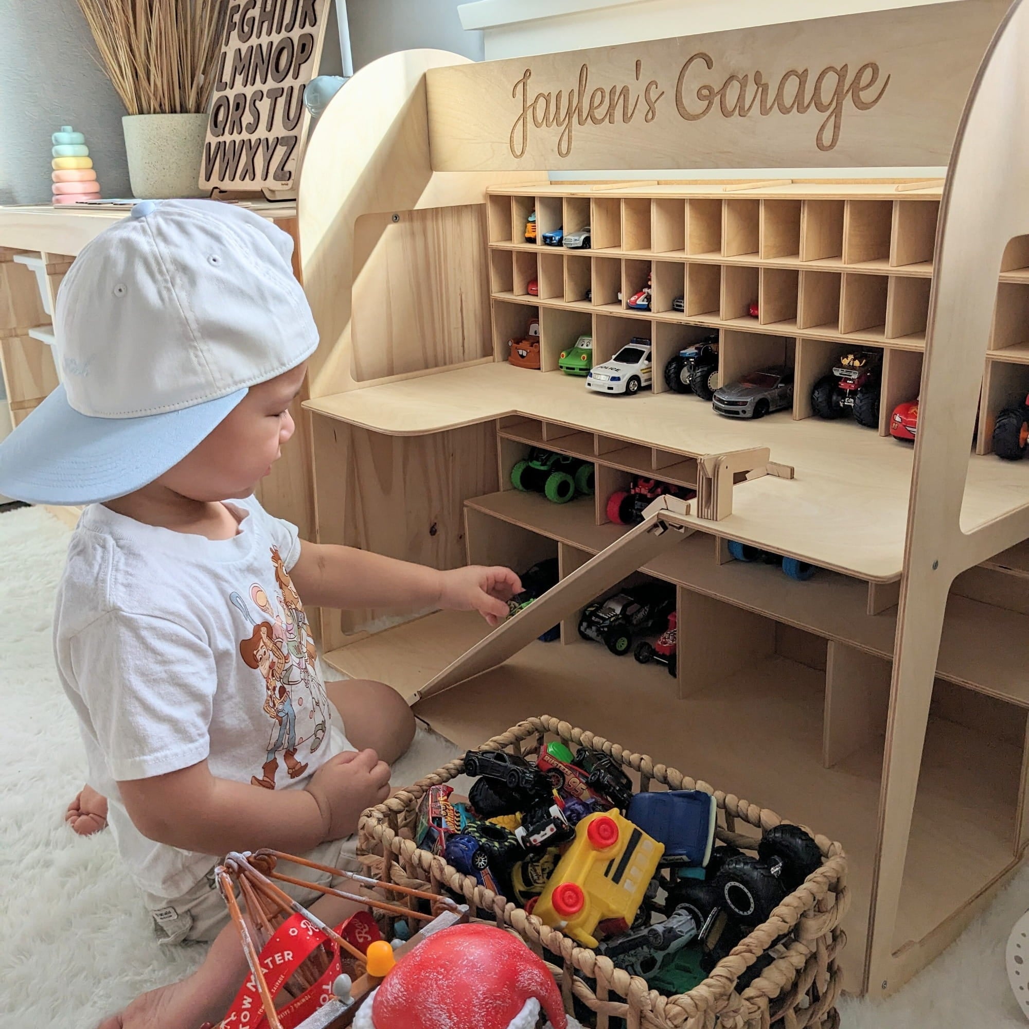 The garage features multiple cubbies, a ramp, and the personalized text 'Jaylen's Garage' on the upper panel.