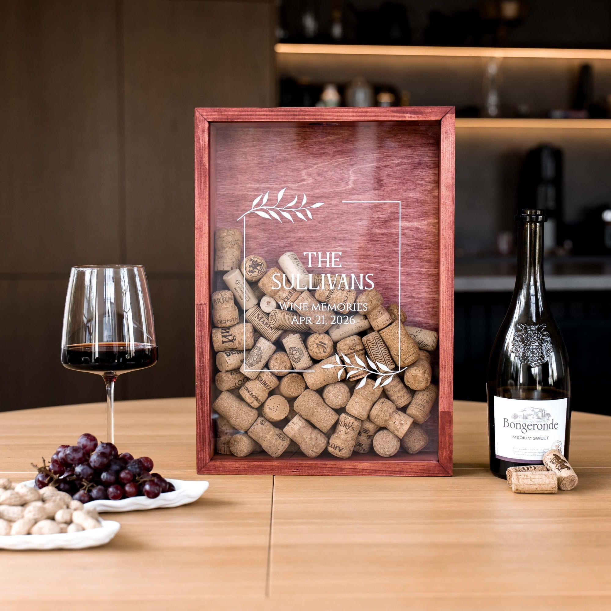A personalized wooden wine gift box with a clear front panel filled with corks