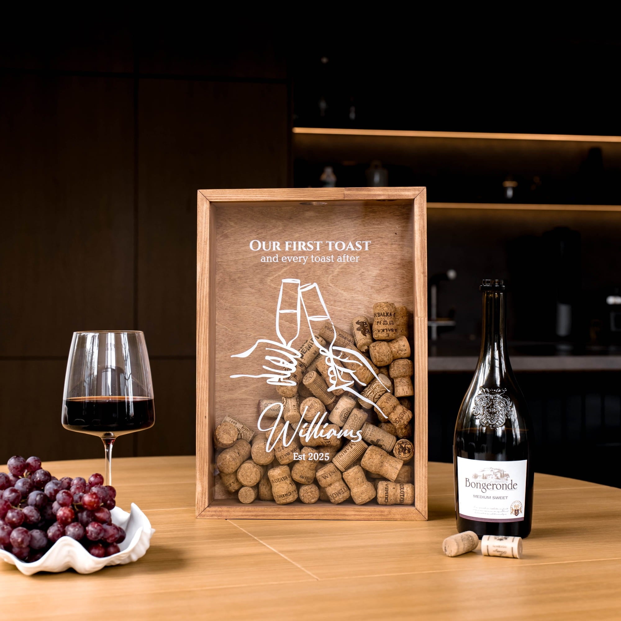 A personalized wooden shadow box plaque on a wooden table, styled with a glass of red wine