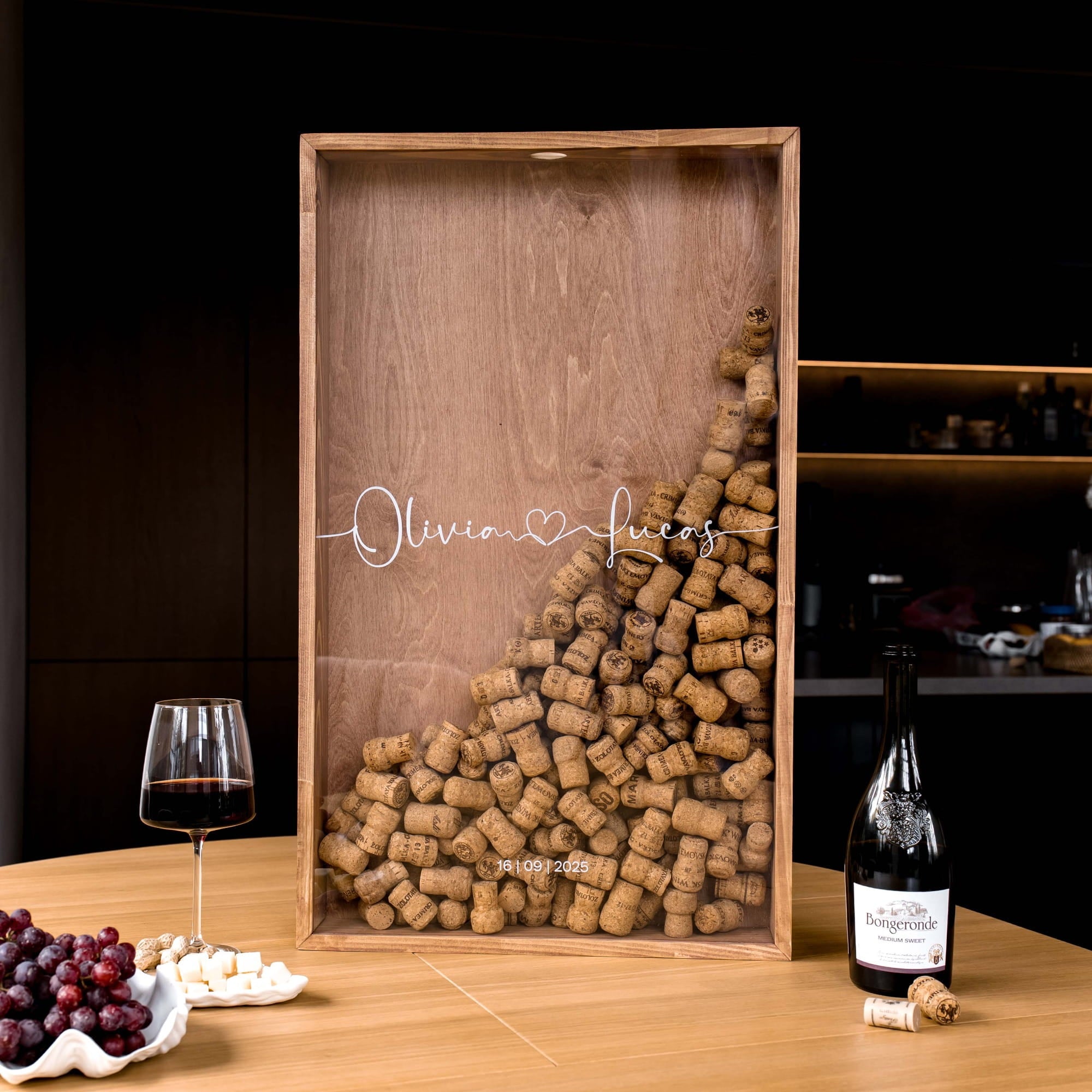A personalized wooden wine gift box with a clear front panel, filled with wine corks in a triangular arrangement